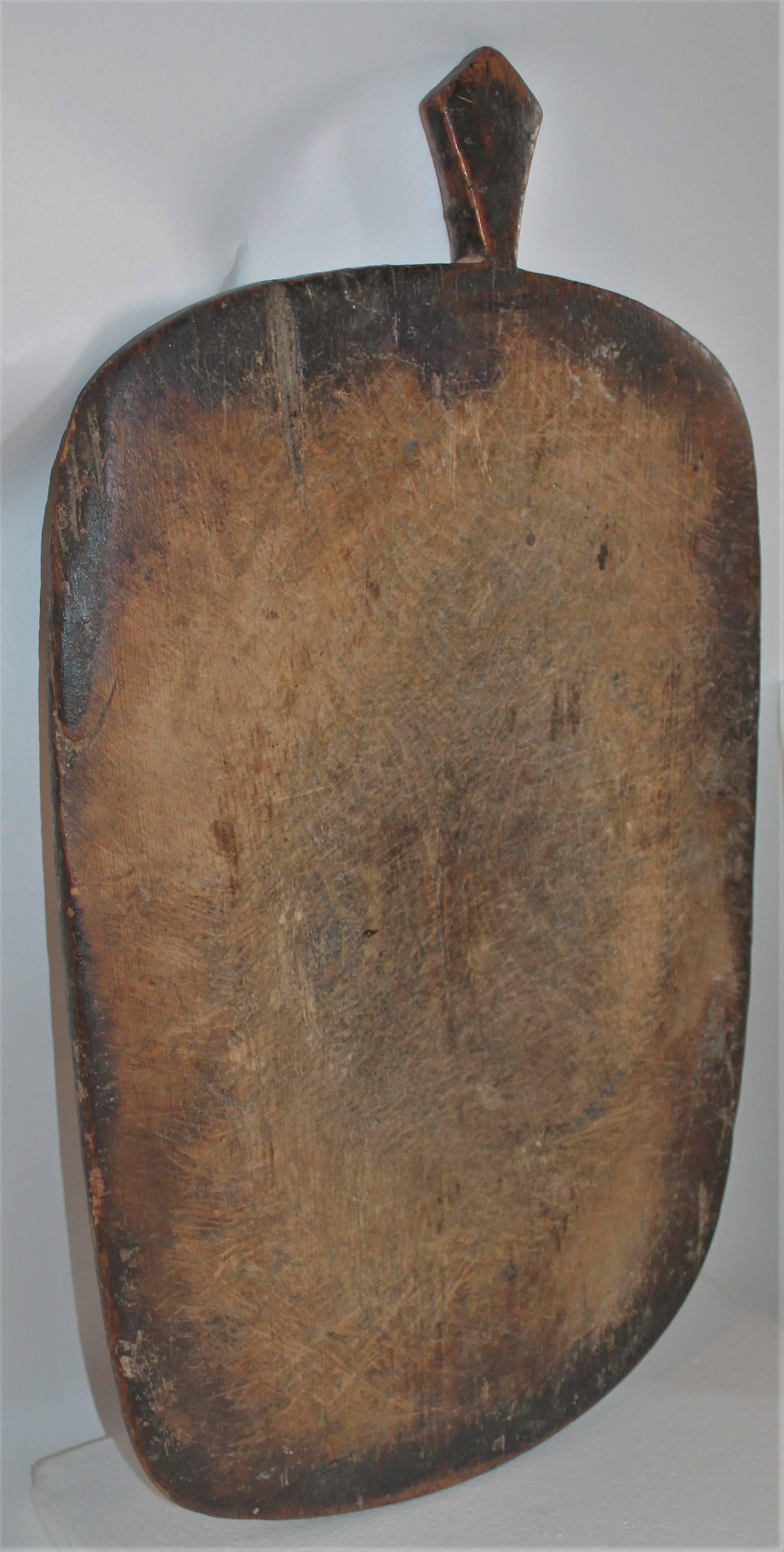 This very early plank cutting board is cut from one piece of wood. The patina is fantastic and condition is very good. Was found in New England. It is wired on the reverse for hanging.