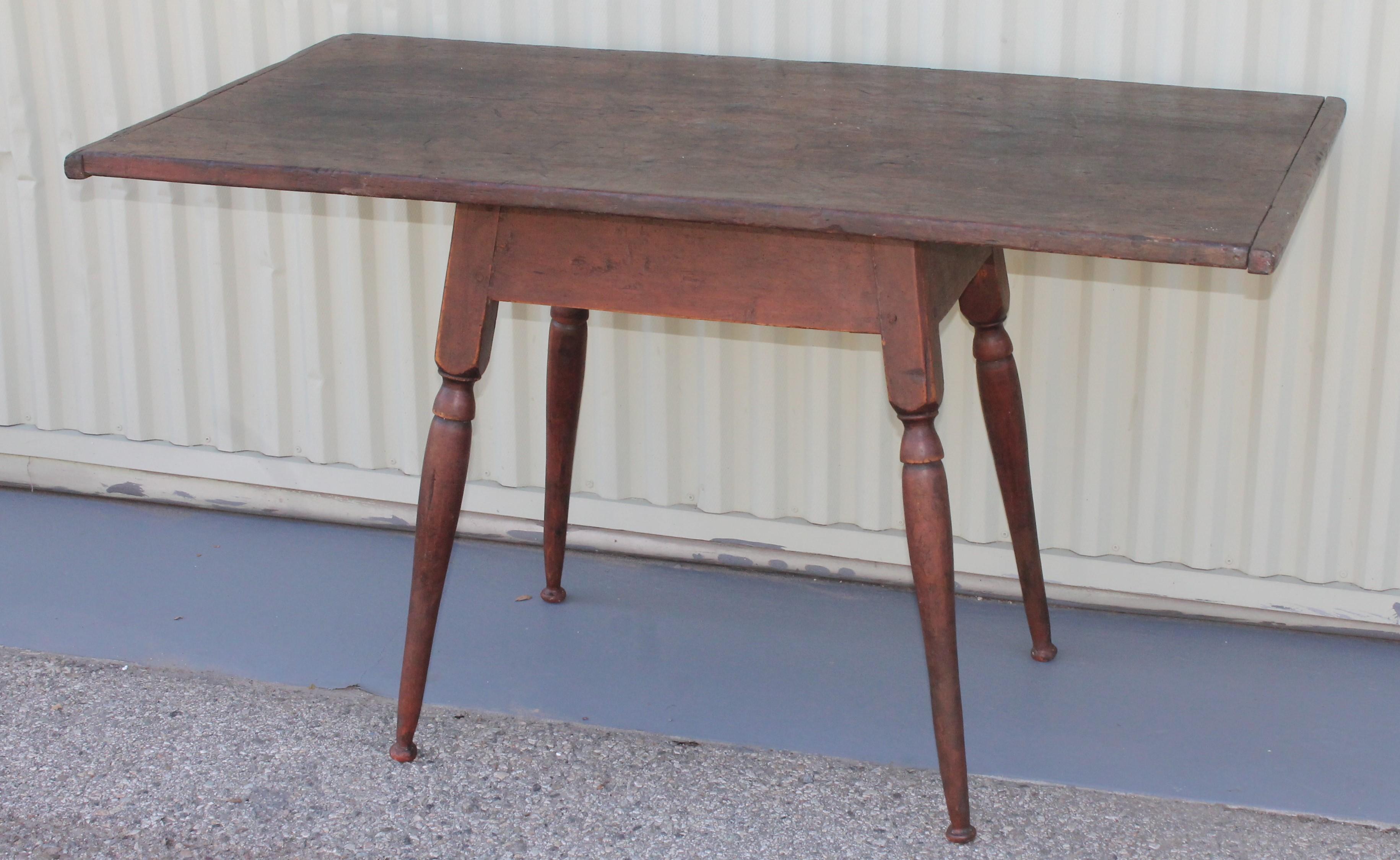 18th century Tavern table from New England in original dark red surface base with a scrub walnut top and bread board ends. This table is square nail and wood peg construction.