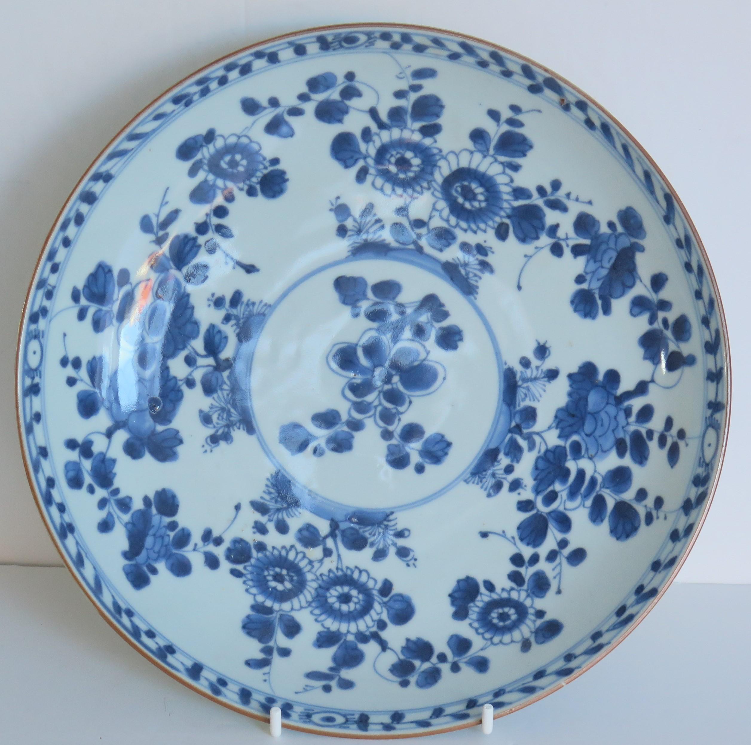 This is a beautiful hand painted blue and white Chinese porcelain large diameter deep plate or charger, dating to the first half of the 18th century, circa 1720, Qing dynasty, either late Kangxi or Yongzheng period.

The plate is well potted and has