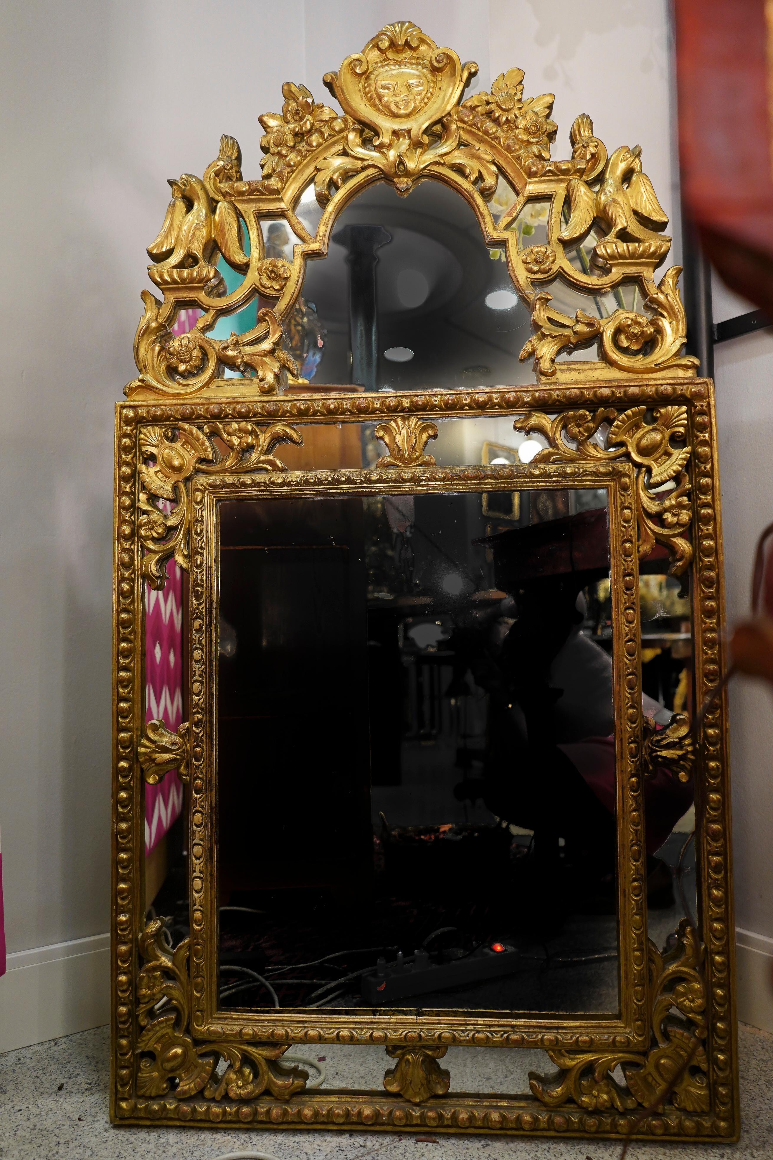 One of a king 18th century French carved and gilded mirror. Double glass mirror with floral carving and rolls, top of the mirror with 2 framed eagle carving and king sun as symbol of King Luis XIV
It’s an exceptional mirror to hold in a master
