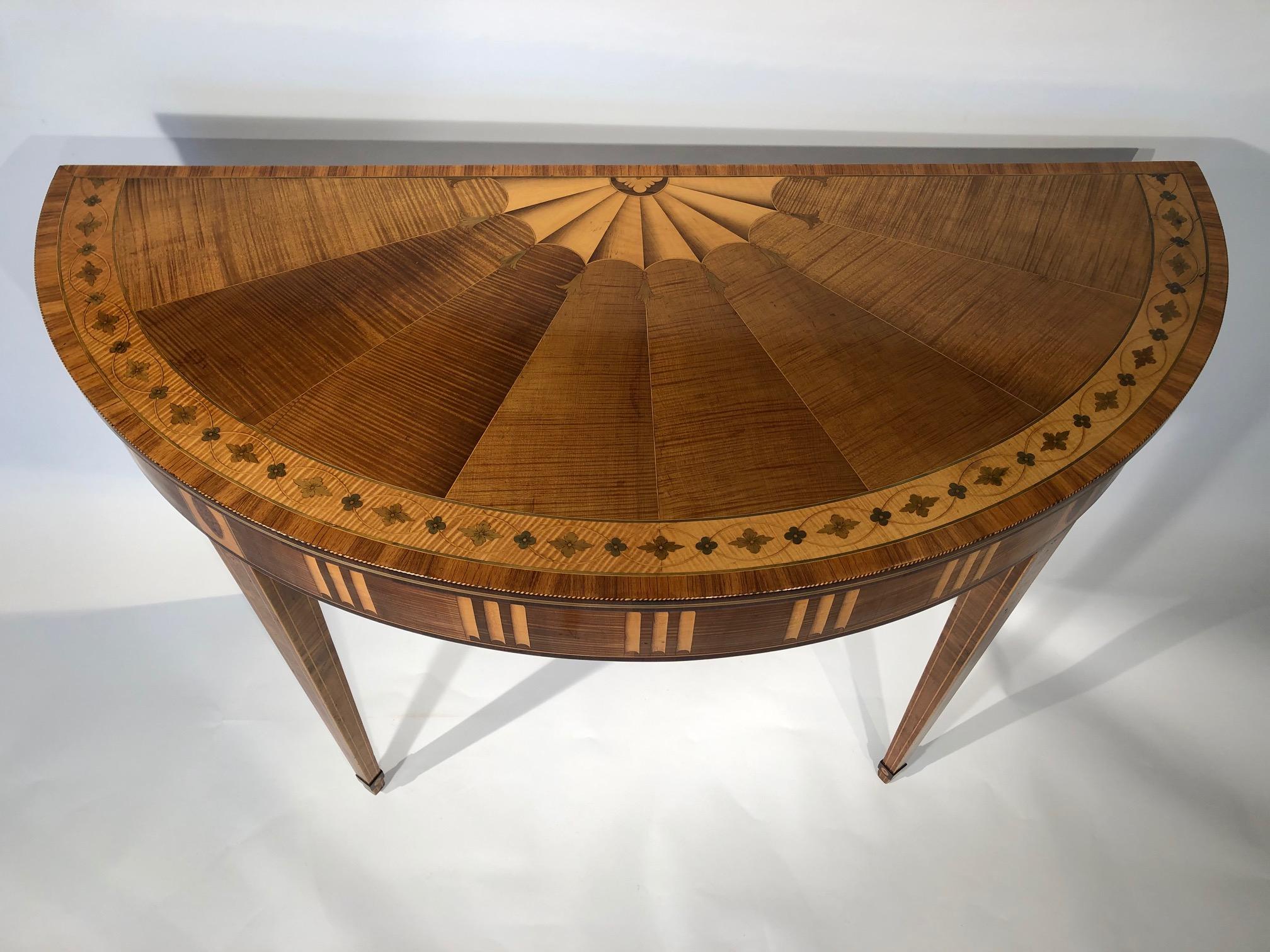 A very fine marquetry harewood demi-lune console table by William Moore of Dublin. The top has radiating paterae within a broad satinwood border enclosing alternating flowerheads. Crossbanded in tulipwood, boxwood and ebony as decoration. The frieze