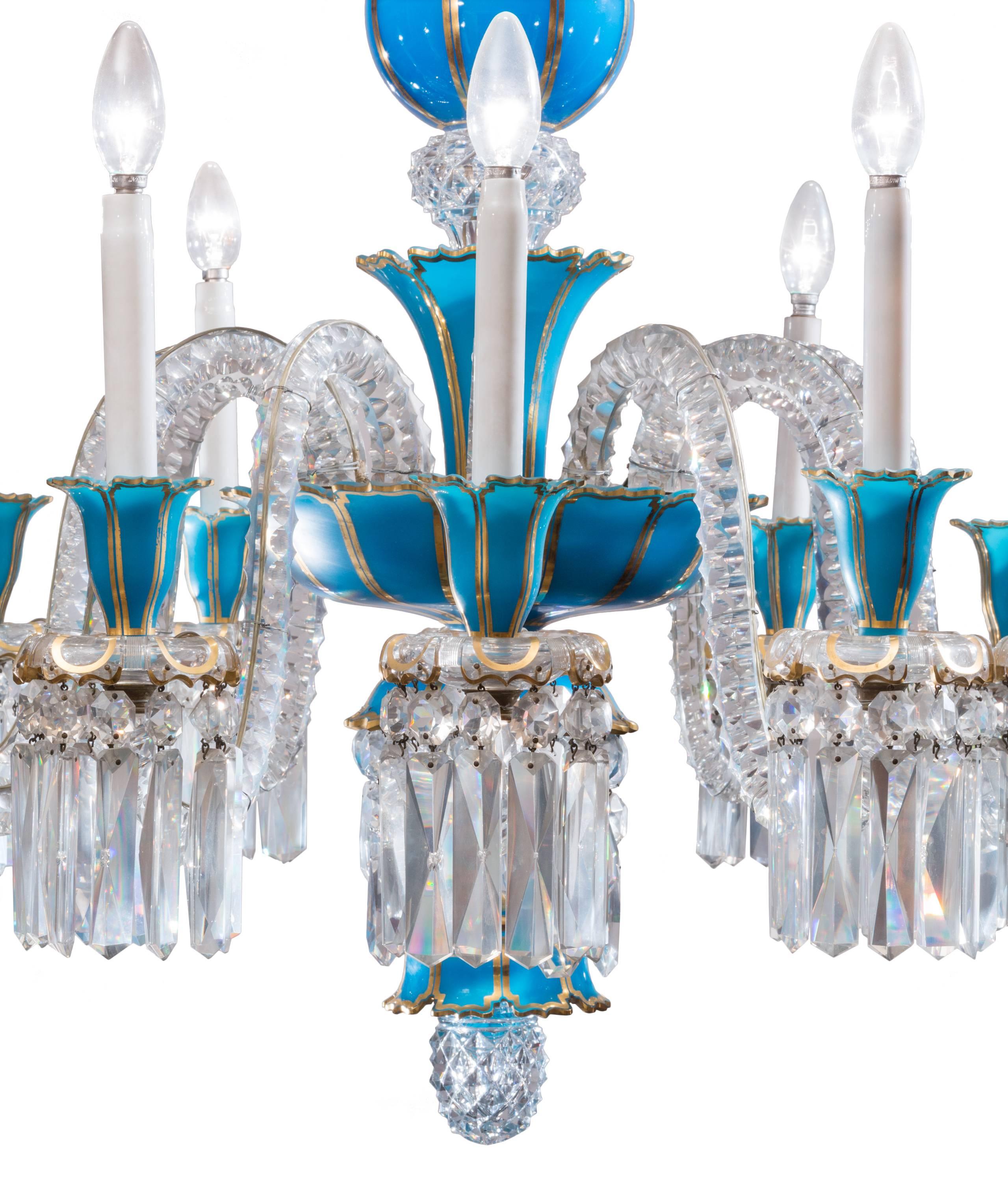 19th century (circa 1840) Baccarat cut crystal and blue opaline glass 12-light chandelier, with hand painted gilt detailing.
Center section supports twelve scrolled crystal candle arms, and is hung top and bottom with pear-shaped crystals, and