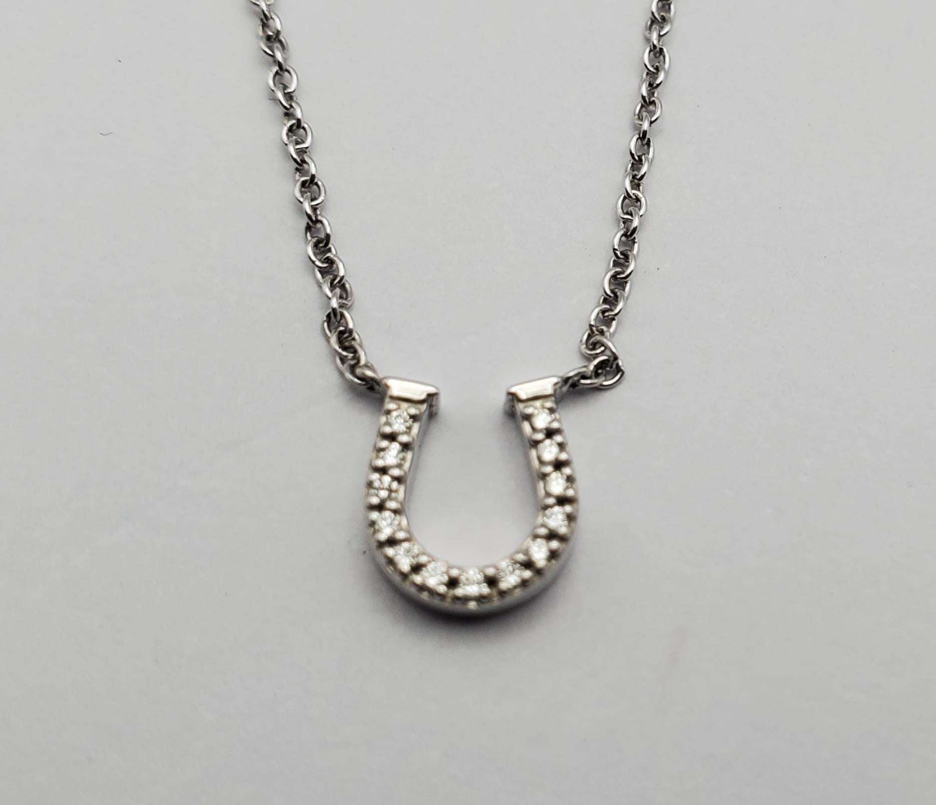 Authentic Tiffany & Co. 18K white gold diamond mini metro horseshoe pendant necklace. The necklace is crafted of 18 karat white gold and features a horseshoe motif pendant accented with 13 round brilliant cut diamonds, approximately .06 total carat