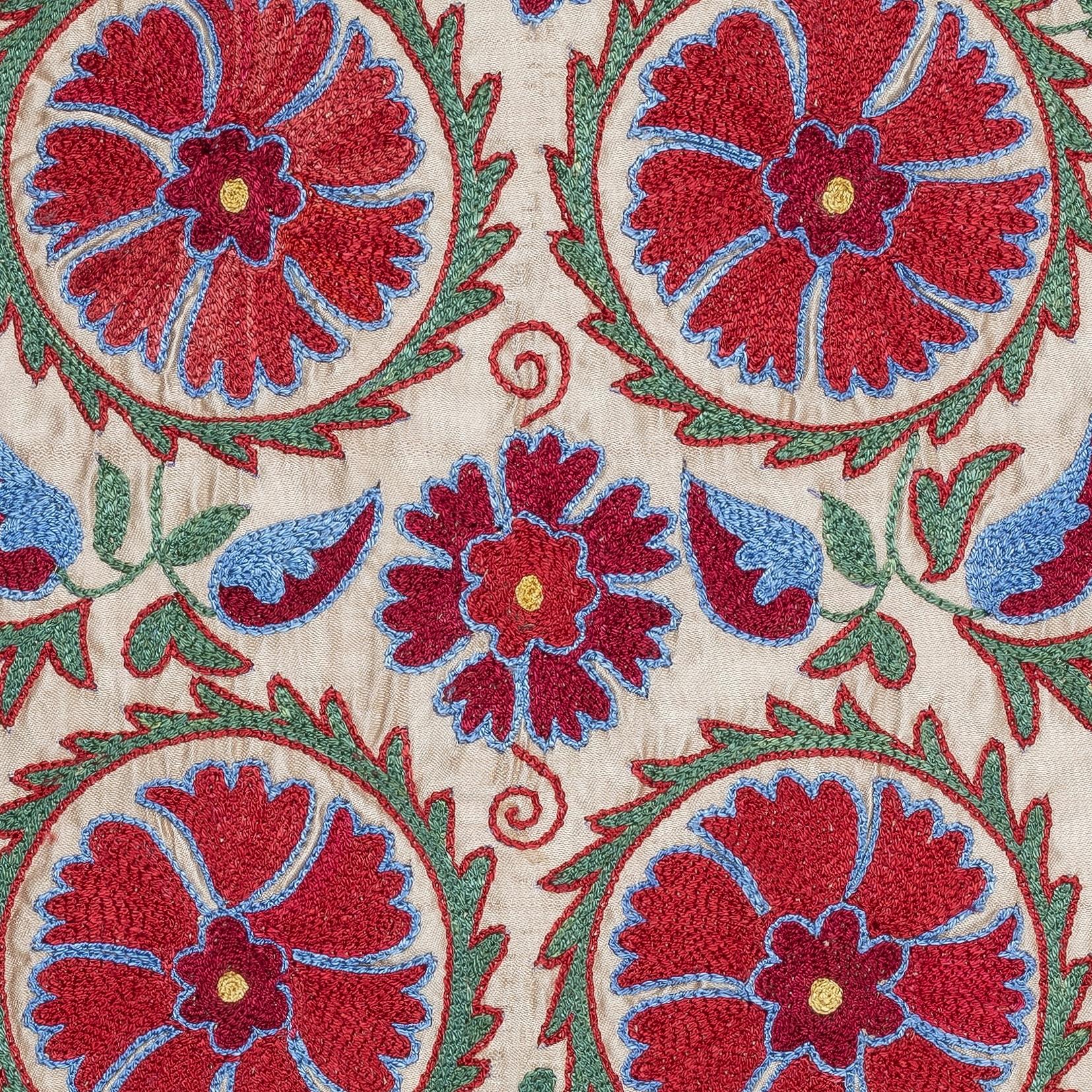 Impregna tu hogar de la rica herencia de Asia Central con esta exquisita Funda de Cojín Suzani bordada a mano por hábiles artesanos de Uzbekistán. Este asombroso tejido es una auténtica obra de arte, con intrincados bordados tradicionales suzani, en