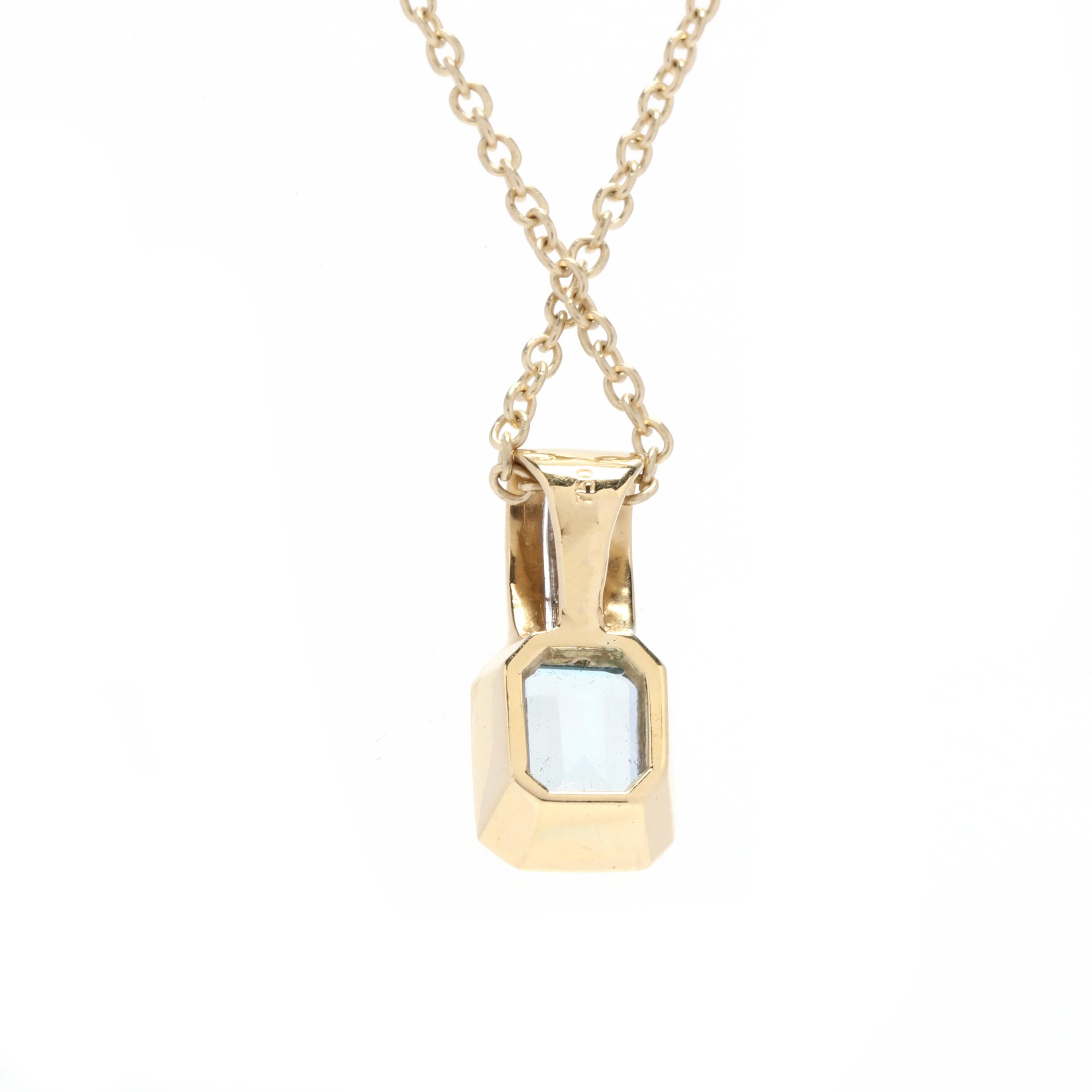 An 18 karat and 14 karat bi-color gold blue topaz and diamond pendant necklace. This necklace features an 18 karat yellow gold bezel set emerald cut blue topaz weighing approximately 2 carats with a bi-color gold wide bail set with two full cut
