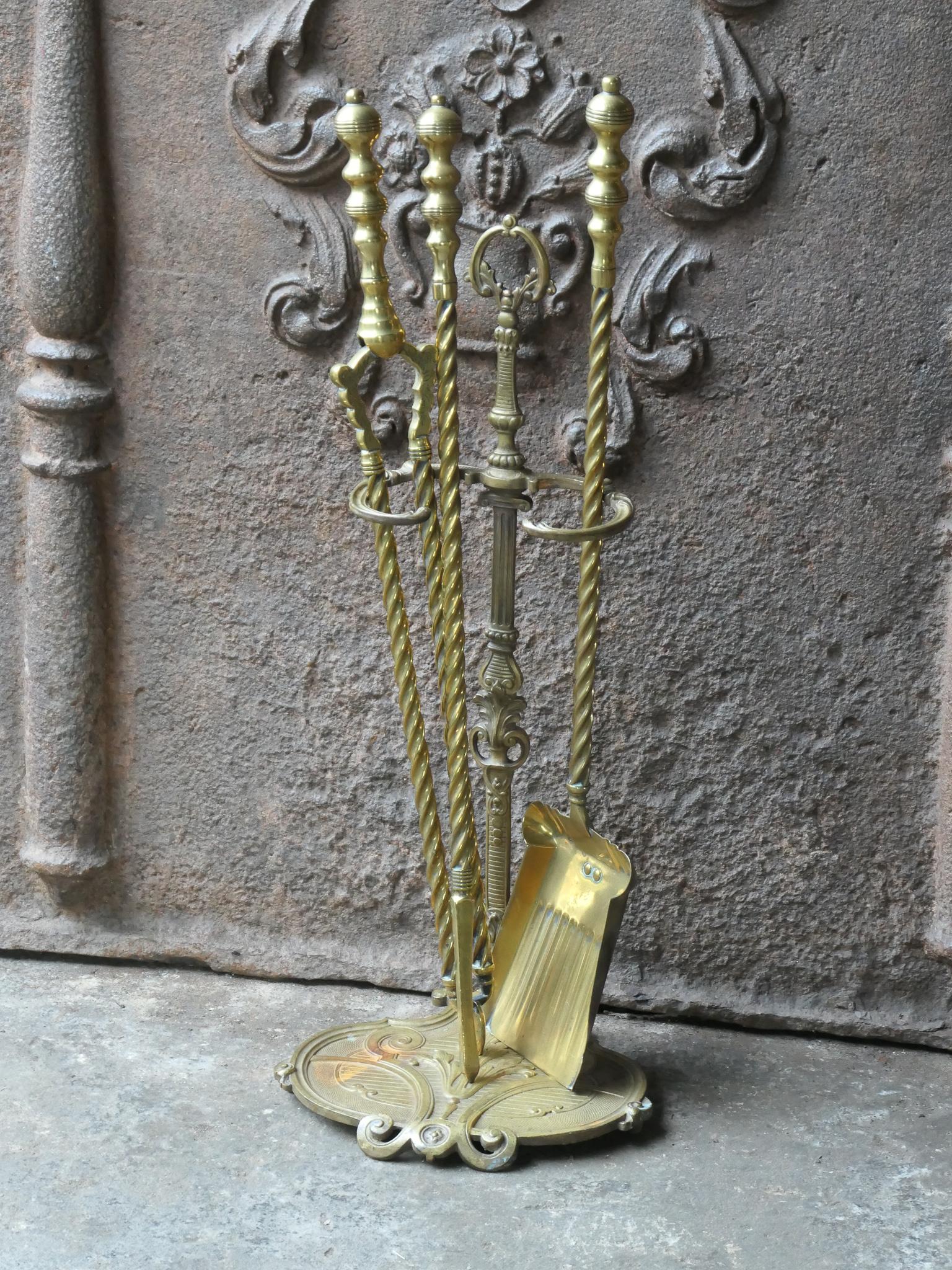 19th/20th Century English Victorian style fireplace tools. The tool set consists of thongs, shovel, poker and stand. Made of brass. It is in a good condition and is fully functional.