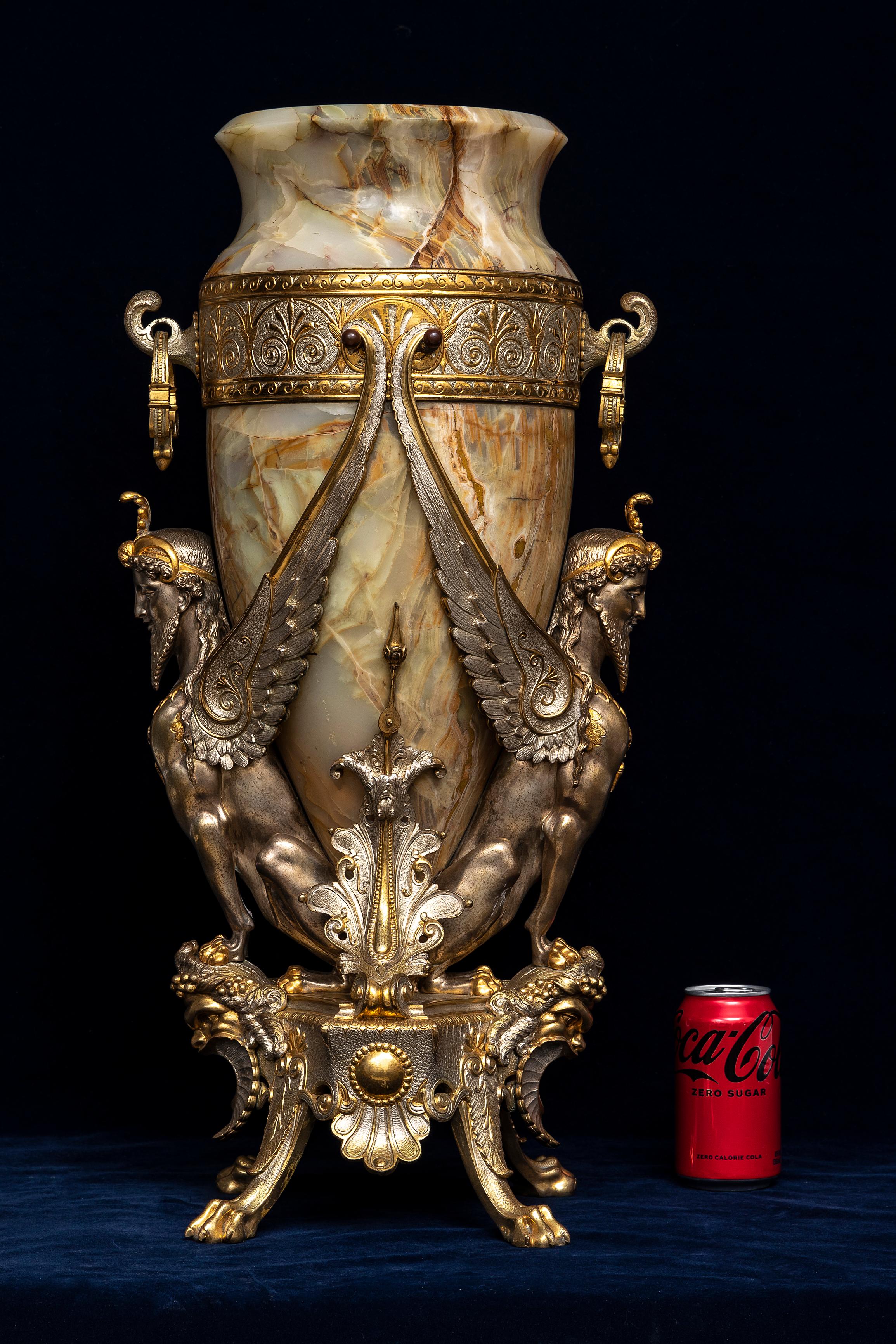 A Large 19th Century French Onyx, Silvered, and Gilt-Bronze Vase Attributed to Charpentier & Cie.  The vase consists of an onyx body with a flared, slightly everted rim and a tapering form that narrows towards the base. The onyx displays a natural