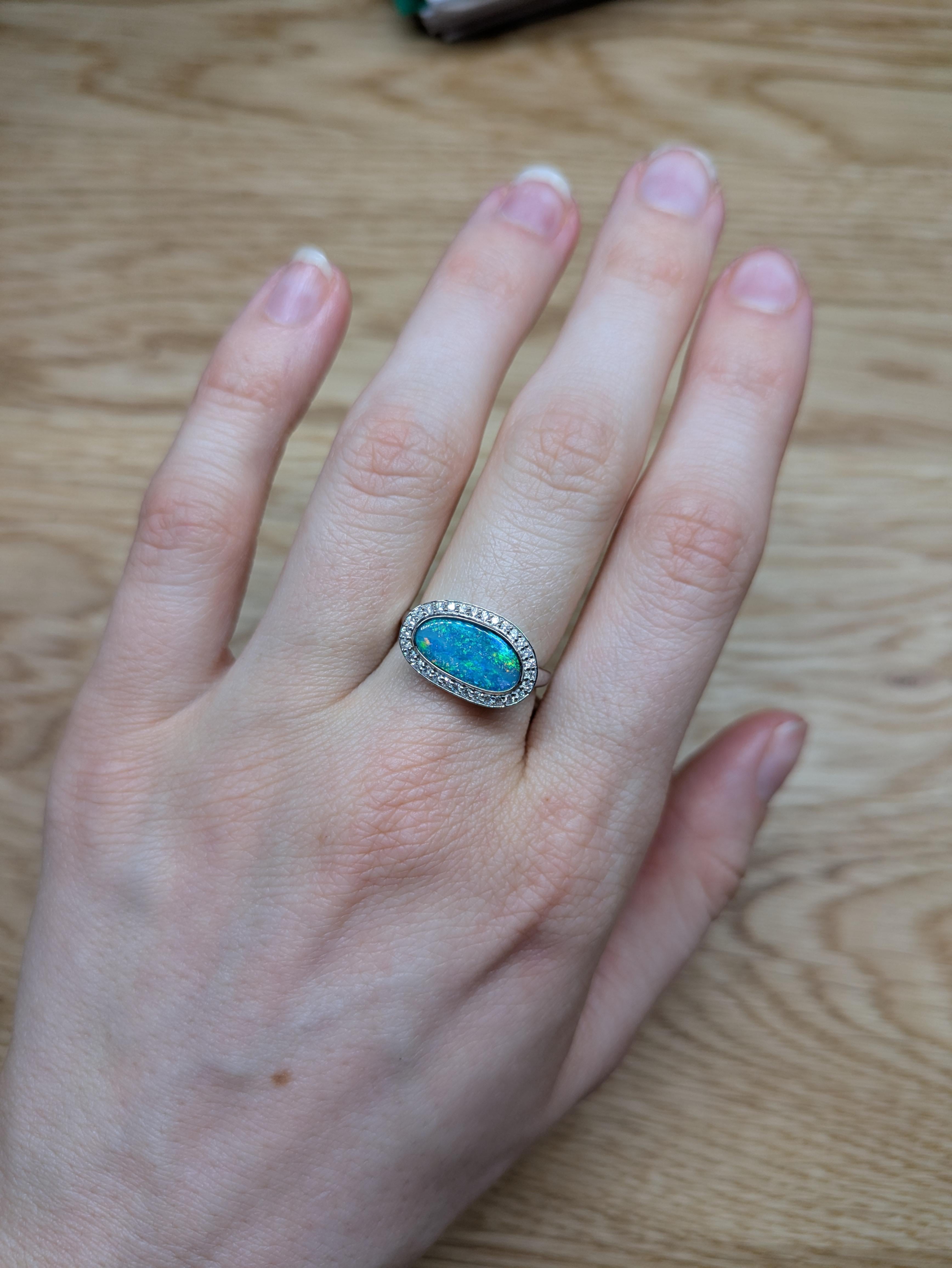This exquisite 1.93-carat Boulder Opal ring features a mesmerizing play of colors, surrounded by a dazzling earth-mined diamond halo. Set in luxurious 14K gold, the fancy-shaped opal showcases its natural beauty, while the shimmering diamonds