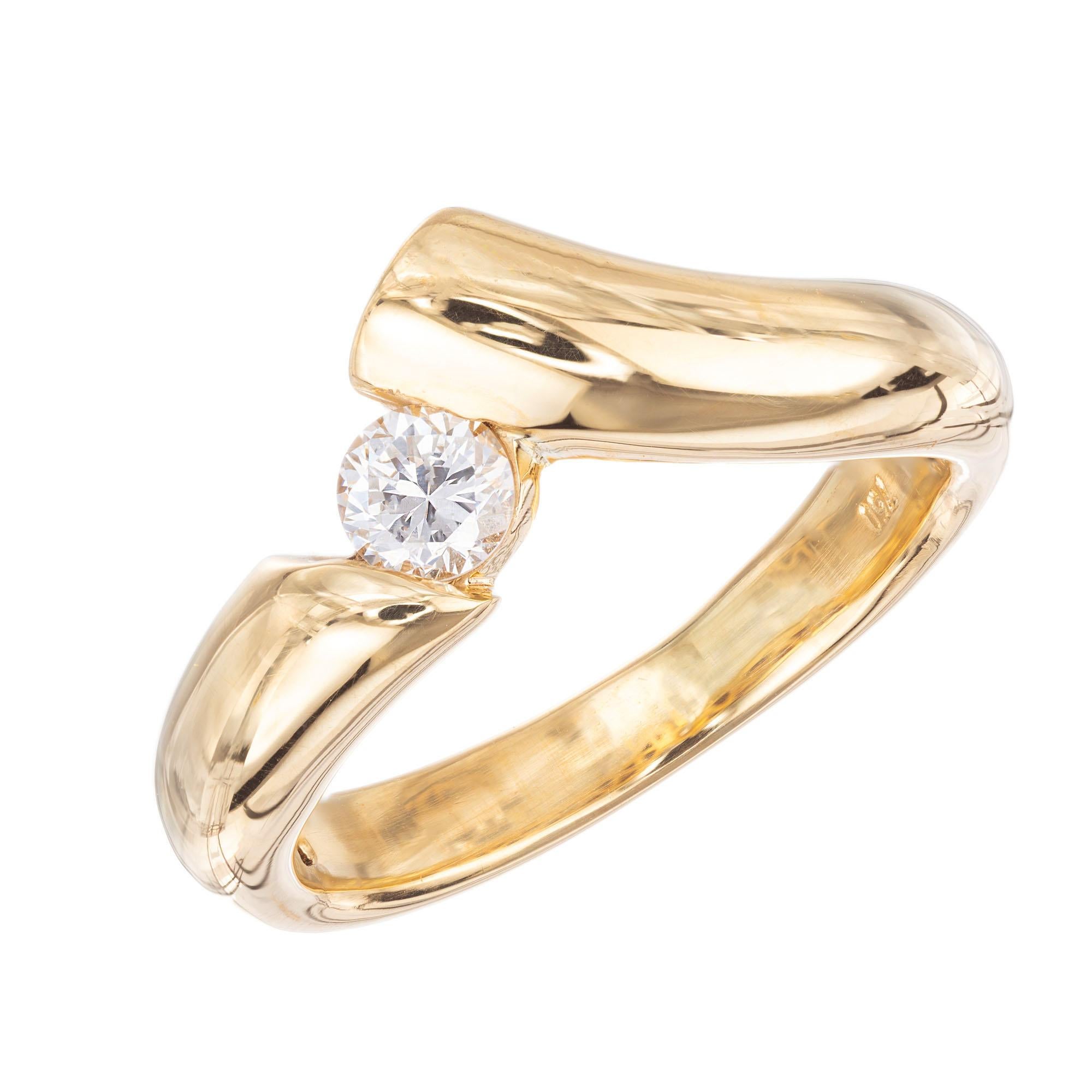 Nonsymmetrical diamond engagement ring. 18k yellow gold setting with a .19 carat round brilliant cut center diamond. 

1 round brilliant cut diamond, H SI approx. .19cts
Size 8.25 and sizable 
18k yellow gold 
Stamped: 750
6.3 grams
Width at top: