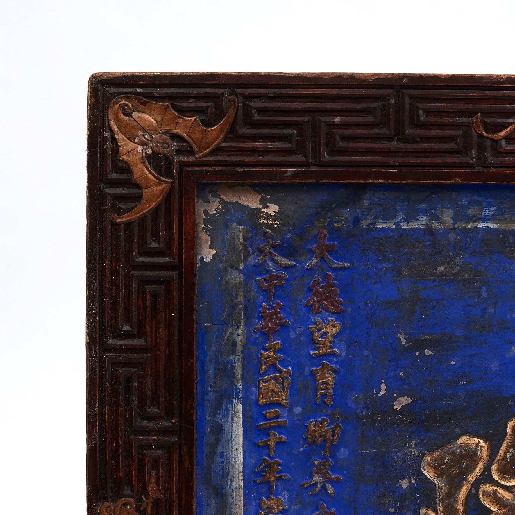 A large Chinese Qing Dynasty period blue lacqured signboard with calligraphy.
The wood carved signboard showcases a frame adorned with carved á la grecque border with vases and bats in the corners. The panel is lacquered with a stunning blue color