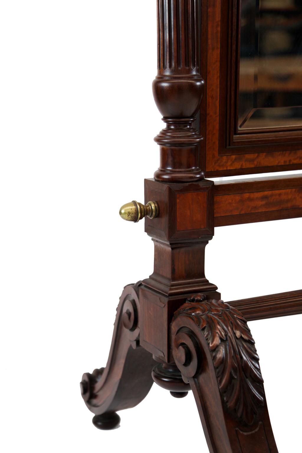 19th century English inlaid mahogany cheval mirror, the arched top rail with center applied crest, inlaid with satinwood and ebony, the turned and fluted stiles above acanthus carved legs terminating with scrolled feet connected with fluted and