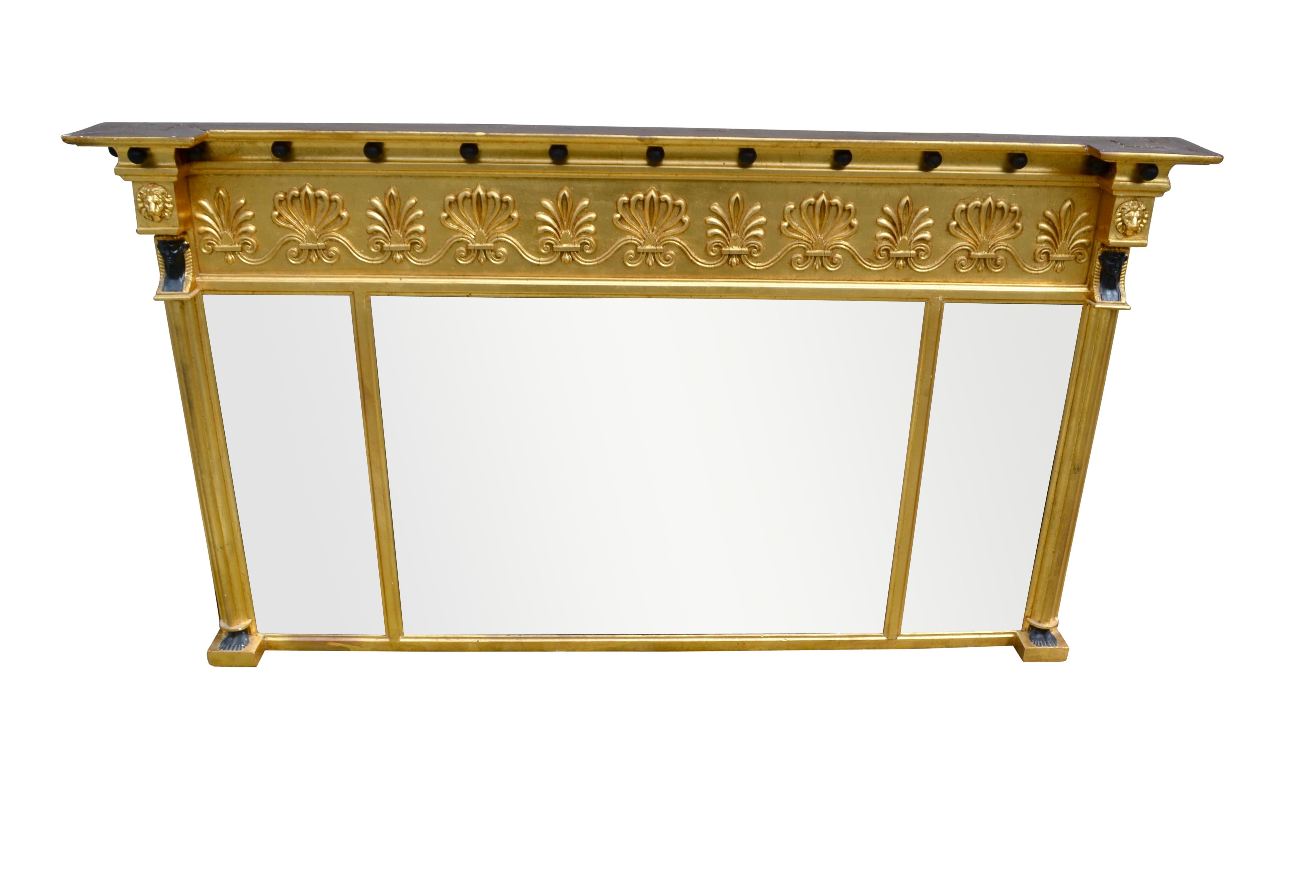 A fine Regency giltwood and composition triple plate overmantel mirror, each mirror being beveled. The frieze is decorated with ebonized balls above alternating acanthus and anthemions. On each side of the mirror frame there is a fluted column