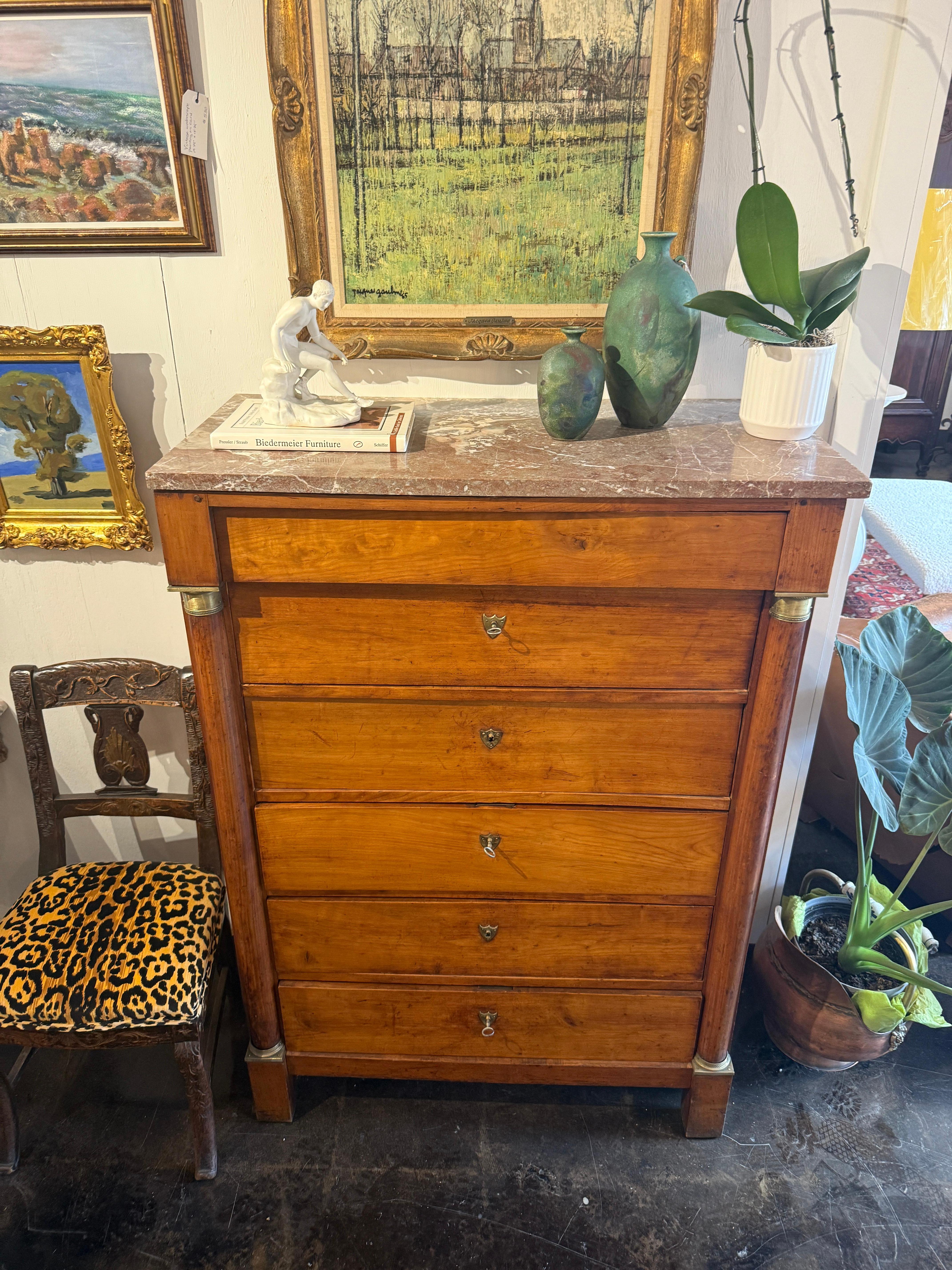 Questa bella commode Impero francese del XIX secolo è stata realizzata in legno di frutto e presenta ormeggi e scanalature in ottone finemente dettagliate. Ci sono tre chiavi per le cinque serrature funzionanti. Il piano è impreziosito da una lastra