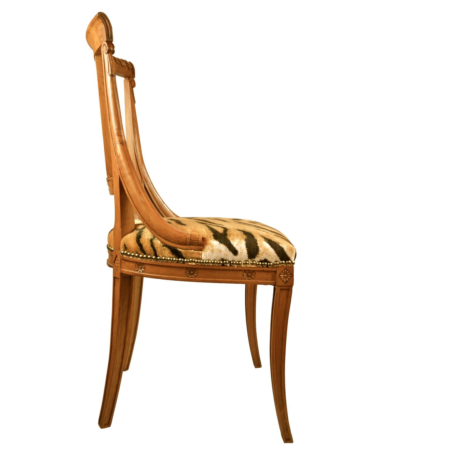 A single neoclassical open chair in crisply carved fruitwood, the back having a decorated carved urn, the top rail with carved palmettes upholstered in modern tiger velvet.
