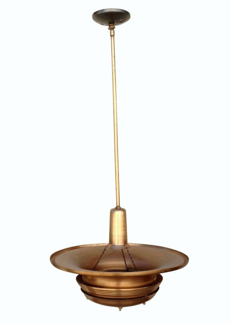 Art Deco era streamlined copper ceiling hanging pendant with a large copper saucer shade connected to a hanging stem.
 
America, circa 1930. the pole can be shortened. Can be almost flush-mounted. Measures: 19