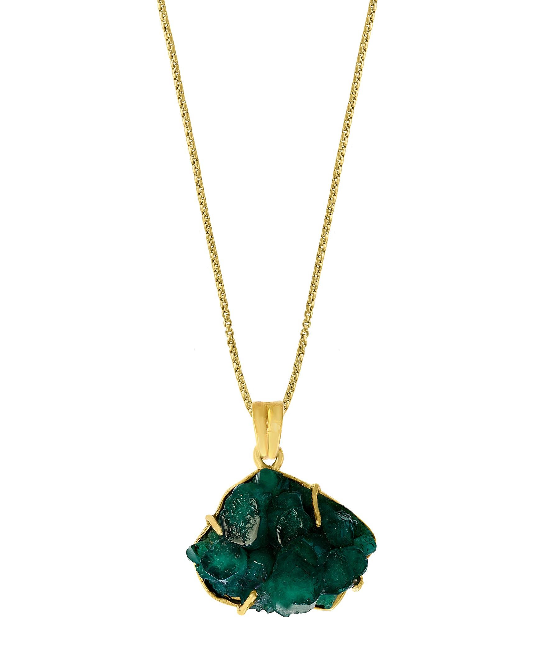 large, breathtaking, statement  piece
This Colombian Emerald Rough Pendant necklace is a eye-catching pendant necklace . It features a large extremely fine  19 ct total weight all set in 18 karat  Yellow Gold. Dangling from a scintillating  bale 