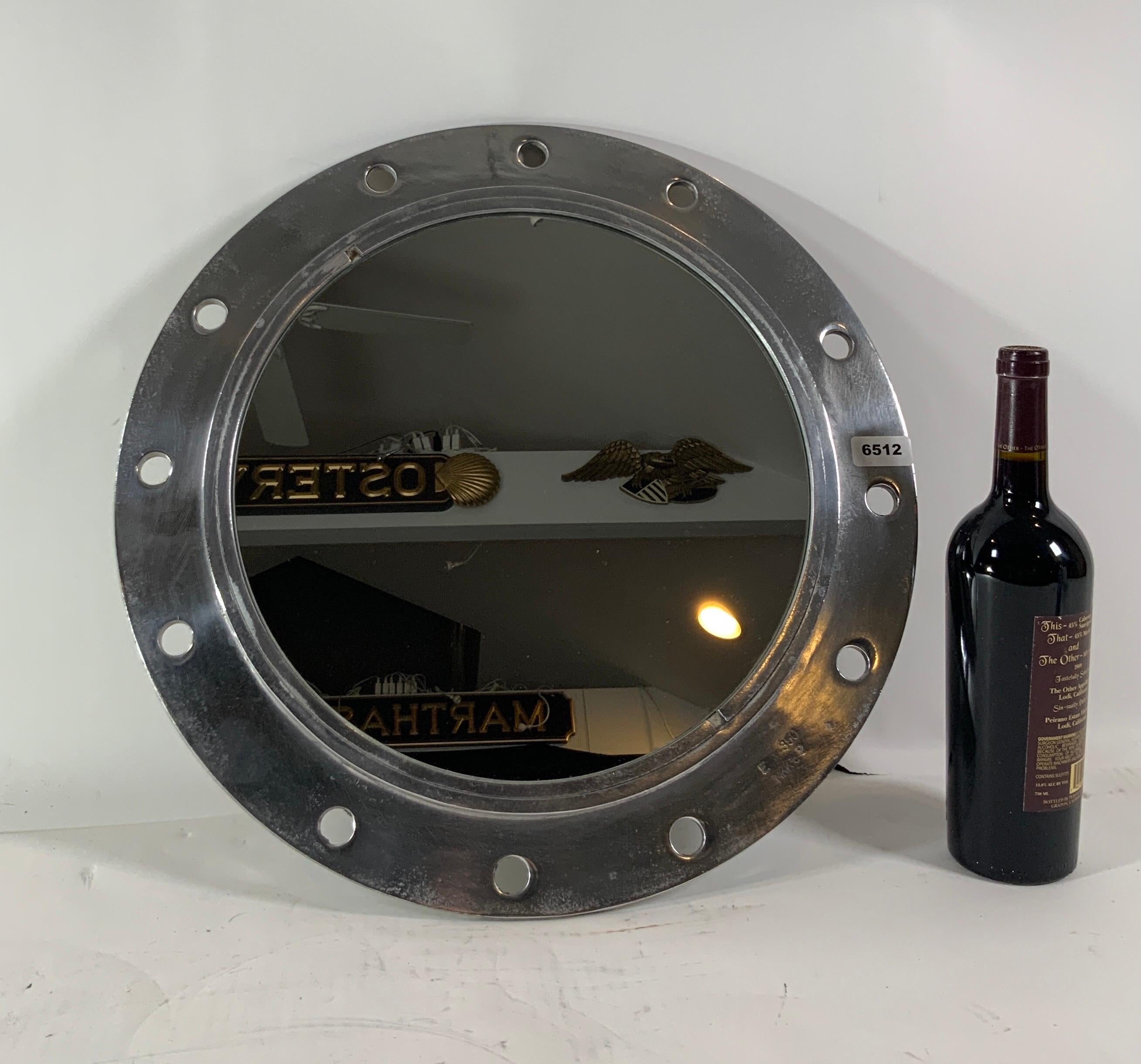 Aluminum ship's porthole with a polished finish and fitted with a glass mirror.

Overall dimensions: Diameter 19.