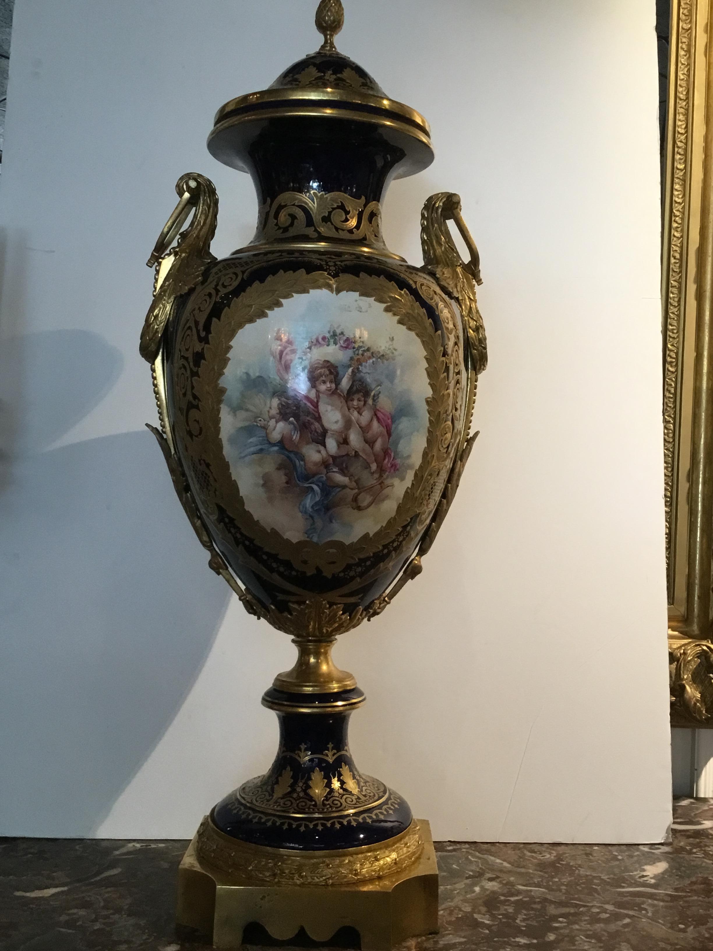 Palace size urn in cobalt and gold hues with playful angels painted
On the front of the urn and floral and foliate designs painted on
The verso. Gilt bronze swirled handles are mounted at the sides.
This piece is Artist-signed on the lower right