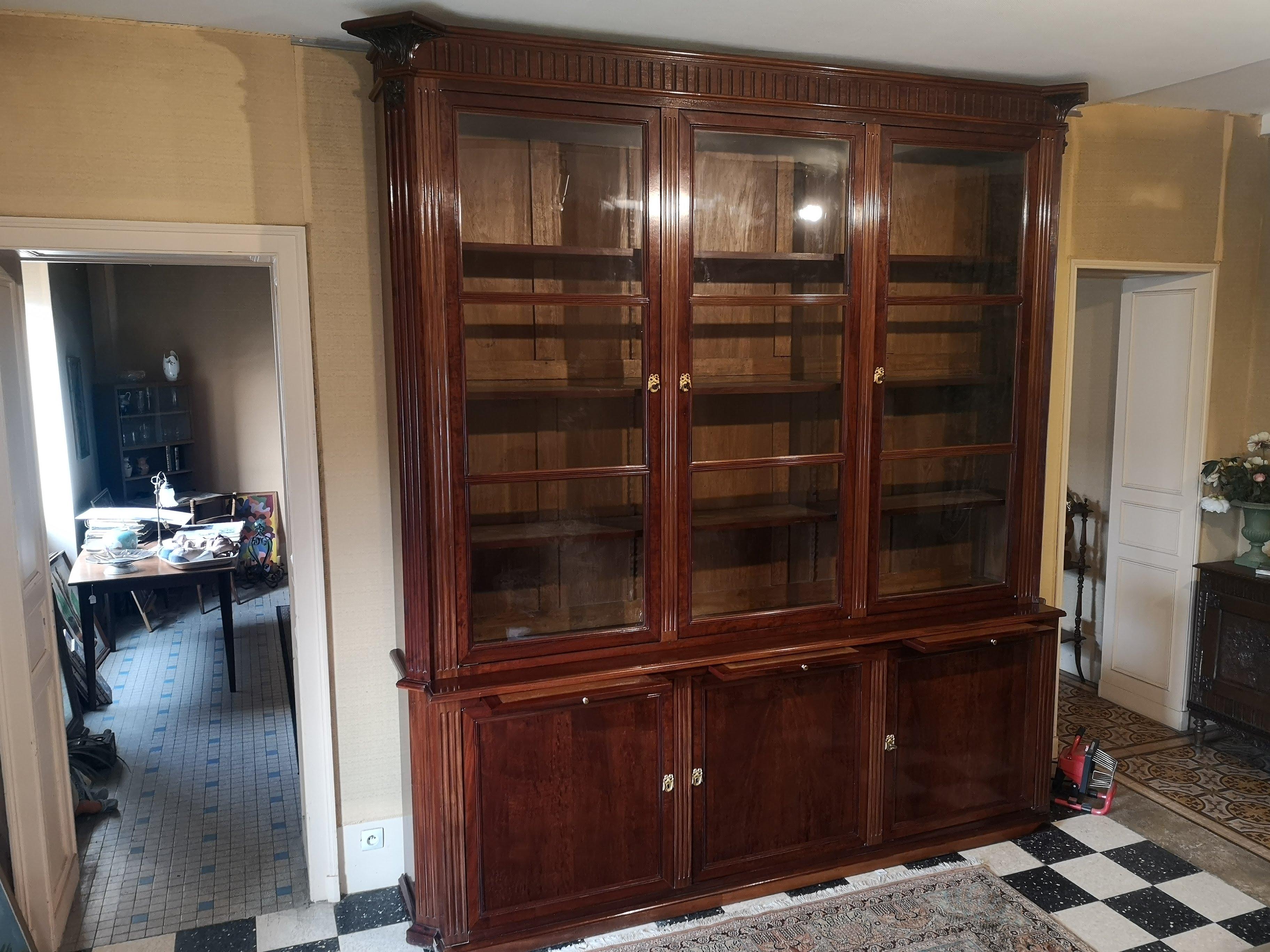 An old library with a staggered body with three large glass doors and solid doors in the lower part.
In belt three zippers decorated with light brown leather with vignette.
The piece of furniture has cut angles, Louis XVI style grooves in the