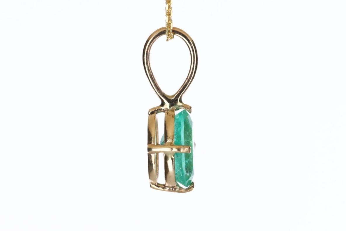 Displayed is a classic Colombian emerald solitaire necklace set in 14K yellow gold. This gorgeous solitaire pendant carries a full 1.90-carat emerald in a four-prong setting. Fully faceted, this gemstone showcases excellent shine. The emerald has