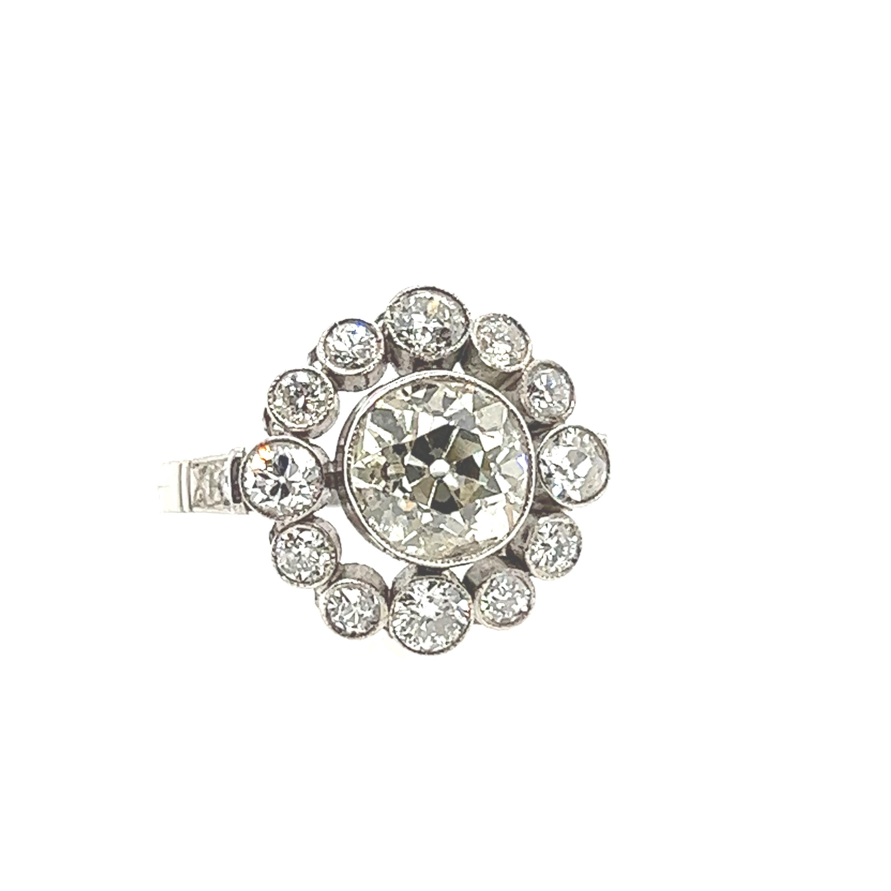 This exceptional antique diamond ring from the 1940s is a true work of art from the Art Deco period. The centerpiece of the ring is a magnificent 1.90-carat European cut diamond, which sparkles brilliantly. Surrounding the center stone are 12