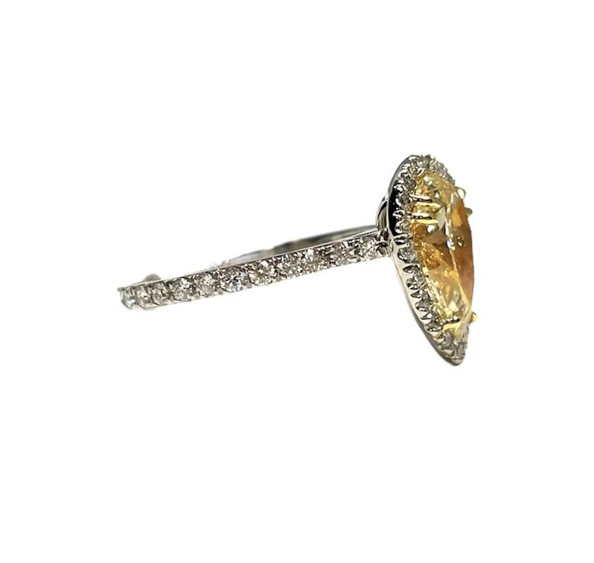 This gorgeous natural yellow diamond ring features one pear shape natural yellow diamond weighing 1.90 ct and VS1 in clarity, surrounded by white diamonds weighing .50ct total set in platinum.