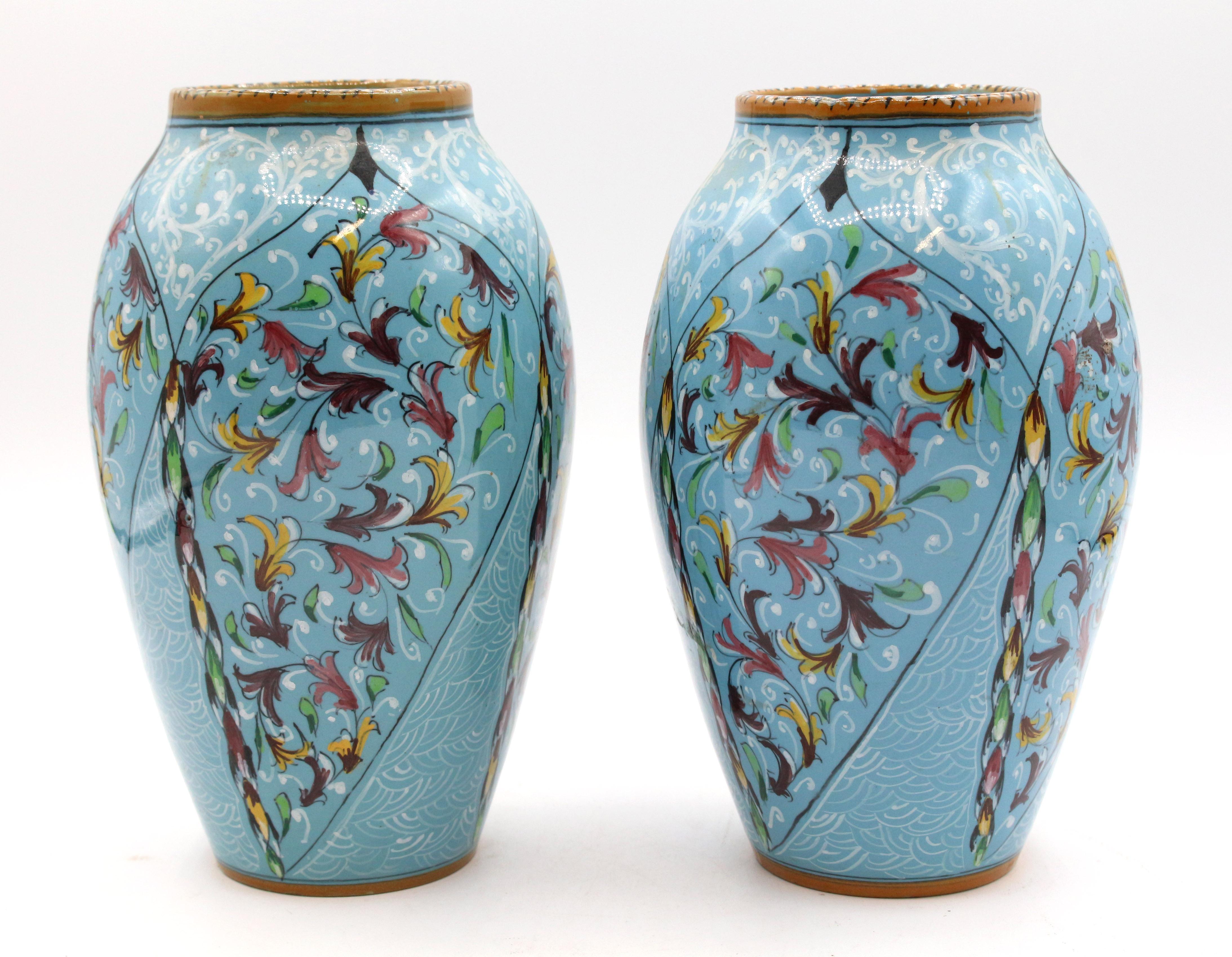 1900-1920s pair of majolica vases by Mengaroni, Pesaro, Italy. Decorated in the Renaissance manner with white tracery & multicolored florets on light blue ground with mustard borders. Ferruccio Mengaroni was crushed to death by his massive majolica