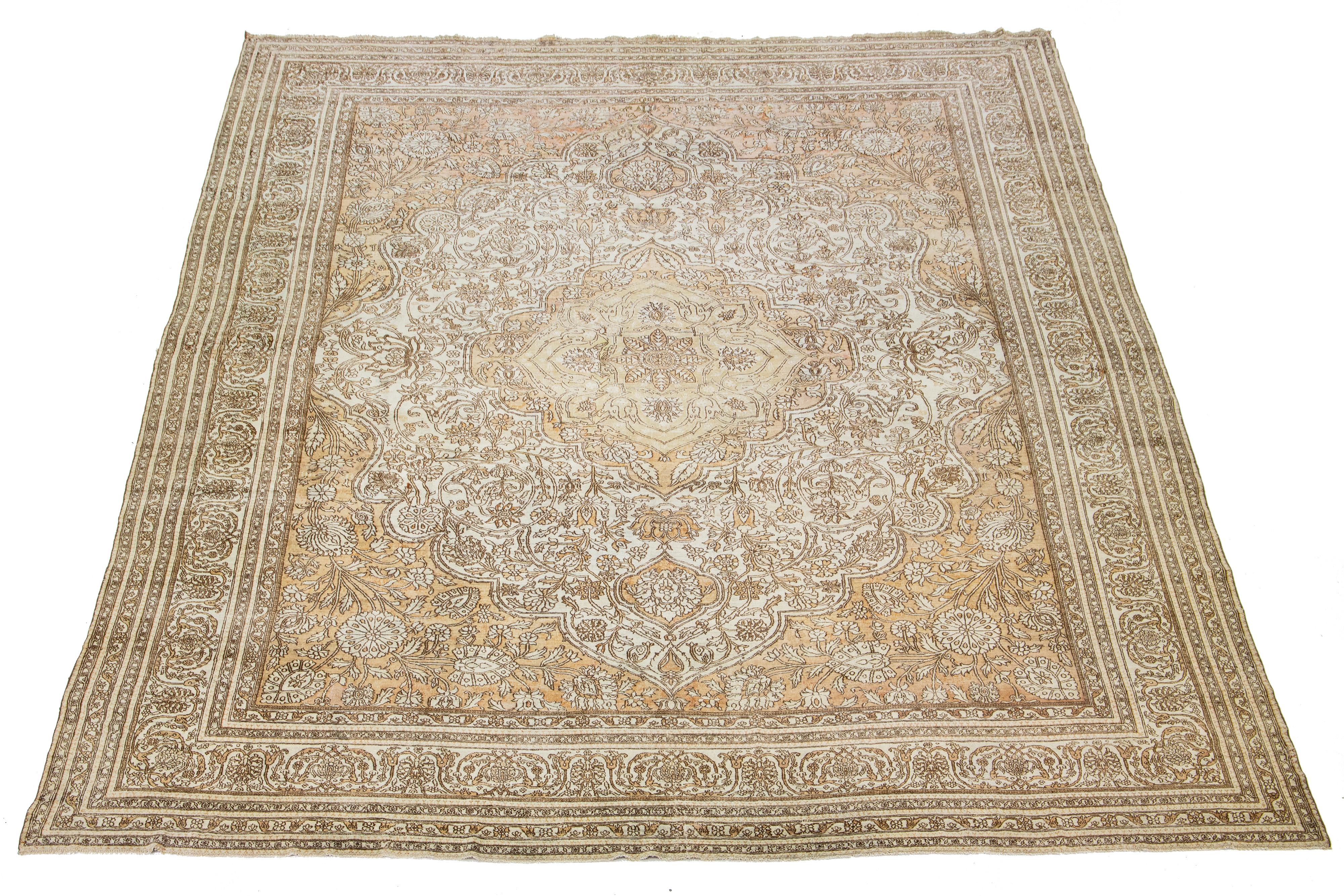 This exquisite hand-knotted Agra wool rug features an ivory field accented by tan motifs in a timeless medallion floral pattern.

This rug measures 12'8