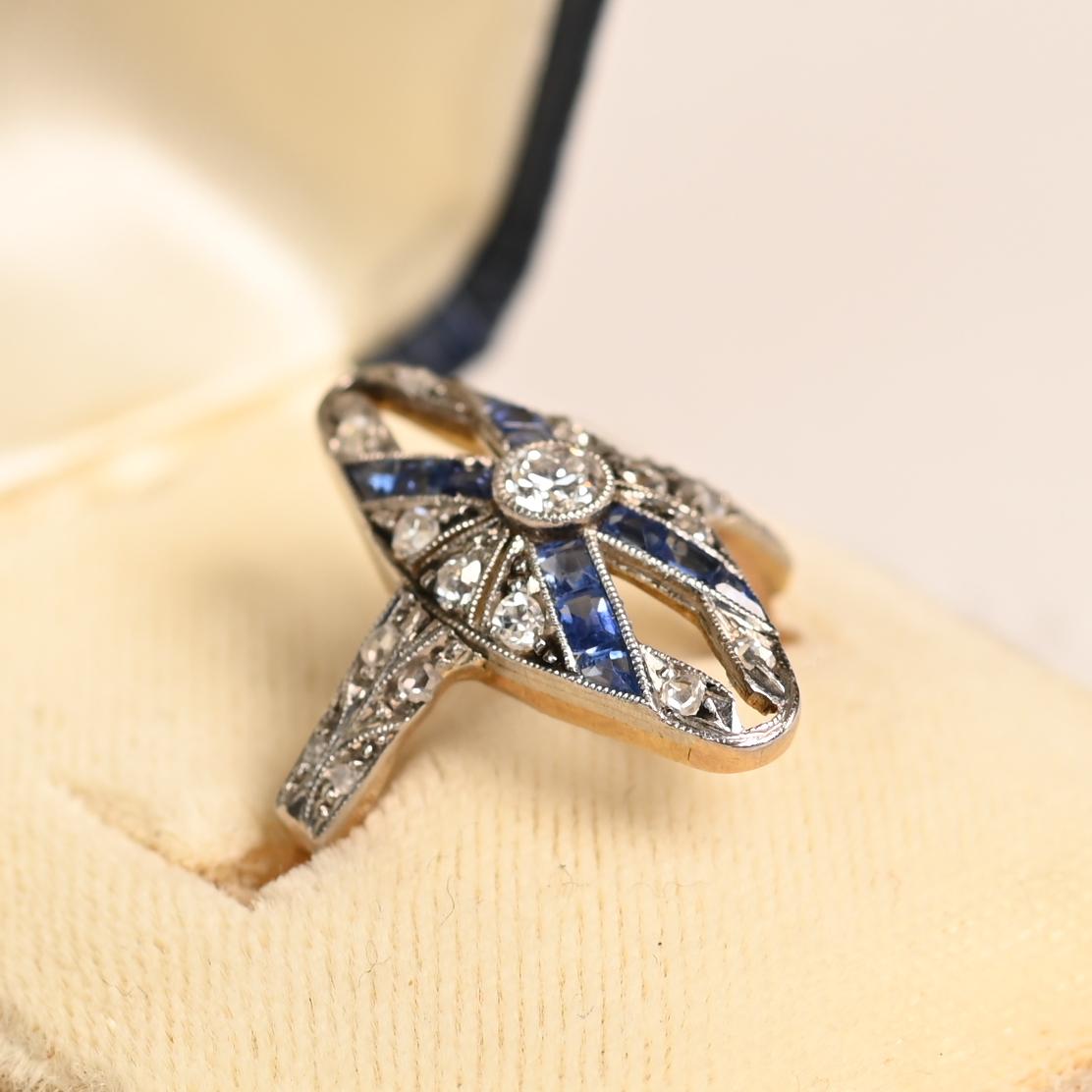 Ein atemberaubender länglicher Diamant- und Saphirring aus der Edwardianischen Ära, handgefertigt um 1900 in Platin über 18k Gelbgold. In seiner Mitte sitzt ein in die Lünette gefasster Diamant im alten europäischen Schliff mit einem Gewicht von