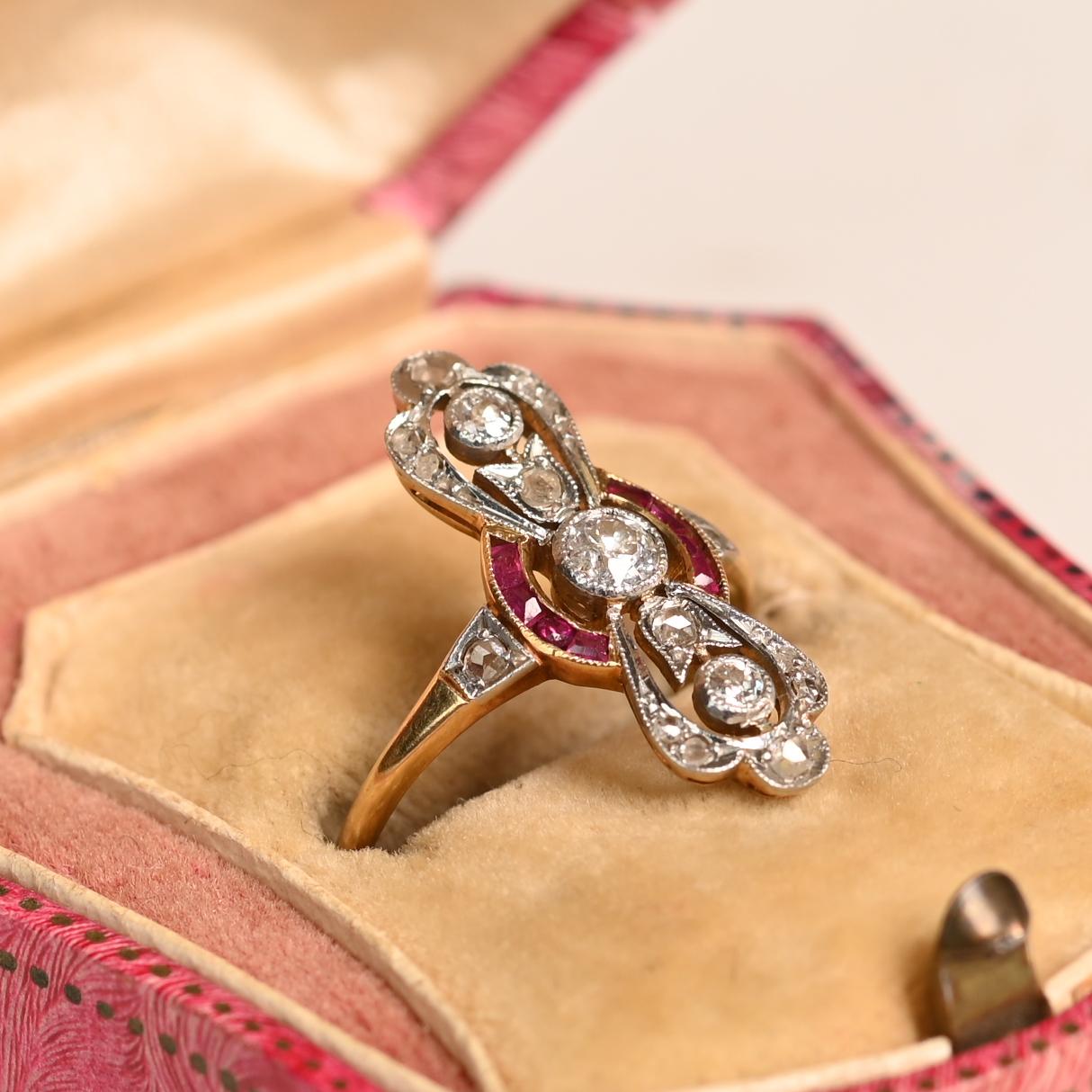 Cette exquise bague ancienne est un chef-d'œuvre de l'artisanat de l'époque édouardienne, datant d'environ 1900. Conçue avec un remarquable sens artistique, elle présente trois diamants ronds sertis sur lunette dans une monture ajourée de forme