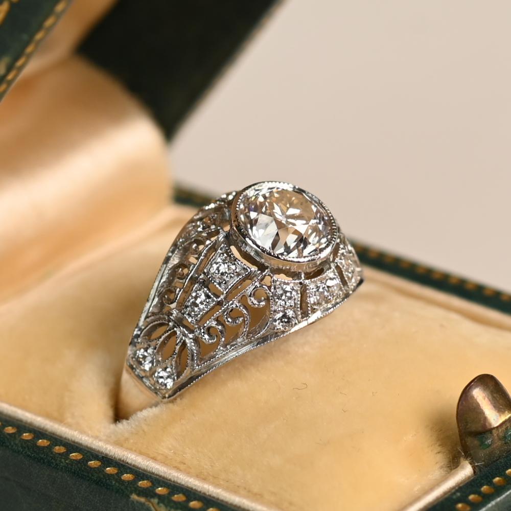 Questo squisito anello di fidanzamento antico mette in mostra uno splendido diamante taglio vecchio europeo da circa 1,10 carati, elegantemente incastonato in delicate griffe. Il diamante centrale, certificato di colore J e purezza VS1, emana una