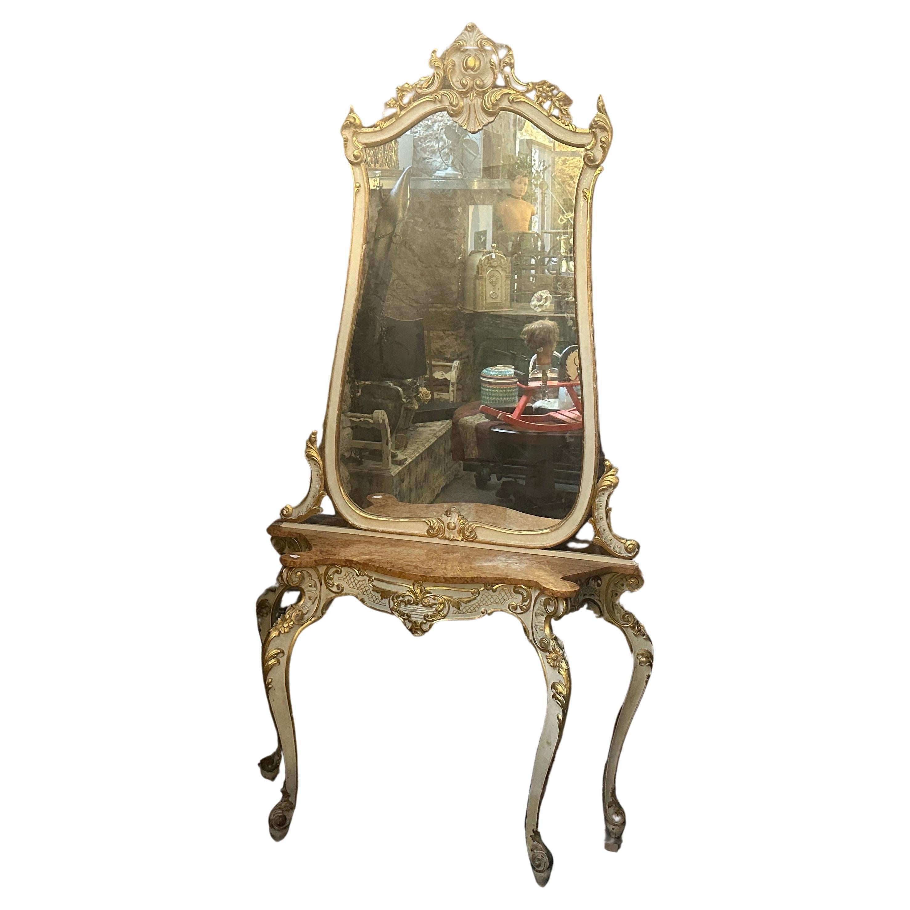 Questa consolle siciliana con specchio è un magnifico pezzo d'arredamento che racchiude l'opulenza e gli elementi di design dell'epoca barocca. Questo insieme è composto da una consolle e da uno specchio, entrambi squisitamente realizzati in legno,