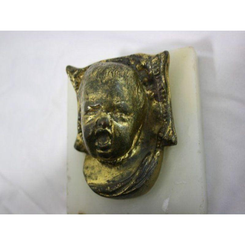 Fermacarte in bronzo del 1900, prima metà del XX secolo, raffigurante una testa di bambino che piange su una base di alabastro nello spirito di Carries, non firmato. Le dimensioni sono 8 cm di altezza, 10 cm di larghezza e 10 cm di