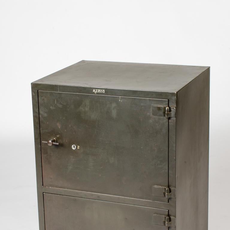 English early 20th-century two-door steel cabinet with a faintly green hue. With its spare, Modernist industrial design, the piece would work well as an end table or occasional piece.  

England, circa 1900

Dimensions: 24W x 20D x 36H