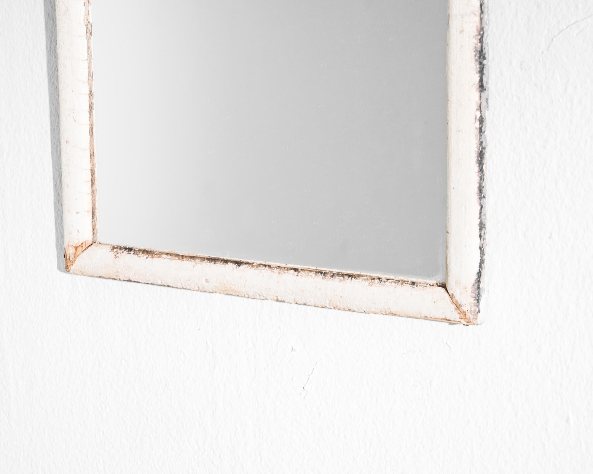 Elevate your décor with the timeless allure of this 1900 French Wood Patinated Mirror. Adorned in an elegant white patina, this mirror exudes vintage charm that has gracefully weathered with the passage of time. The simplicity of its design,