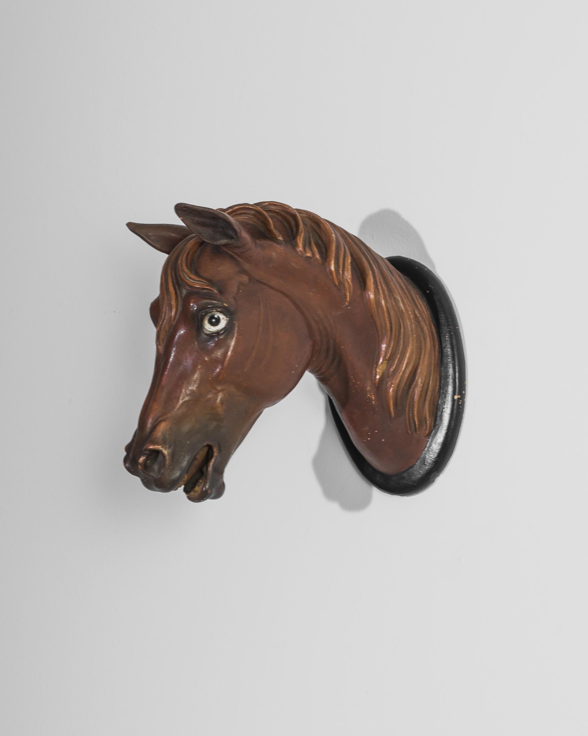 protome, this wall sculpture was made in the UK circa 1900. As if depicted in motion, wide open eyes, flaring nostrils and a passionate neigh frozen on its lips, this realistically molded horse head exudes the bold energy of an untamed animal. A