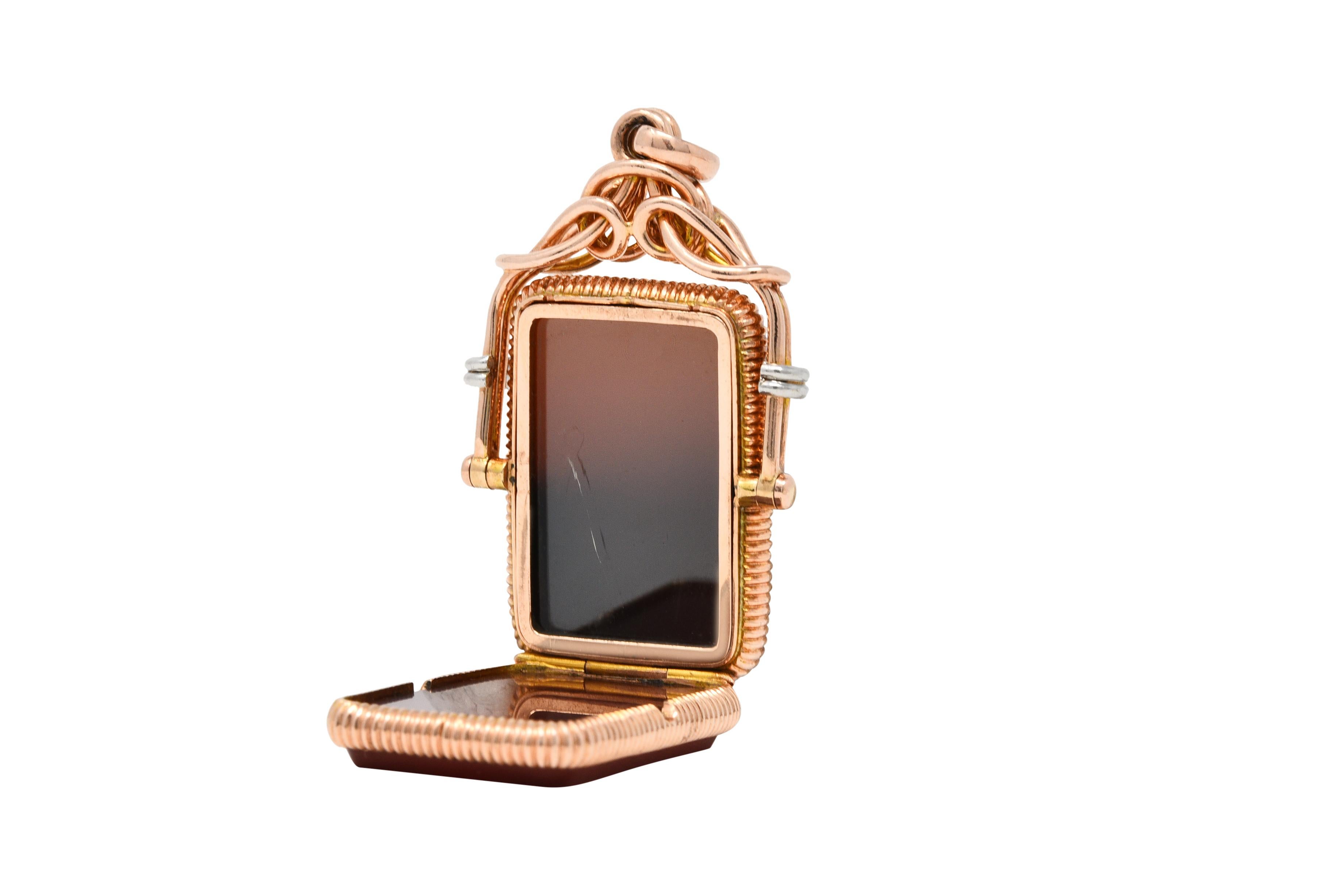 Ribbed rectangular locket features two rectangular chalcedony tablets measuring approximately 24.5 x 17.0 mm

Locket rotates on an axis flipping between a polished tablet of bezel set sard and a carnelian intaglio

Sard is opaque with dark and