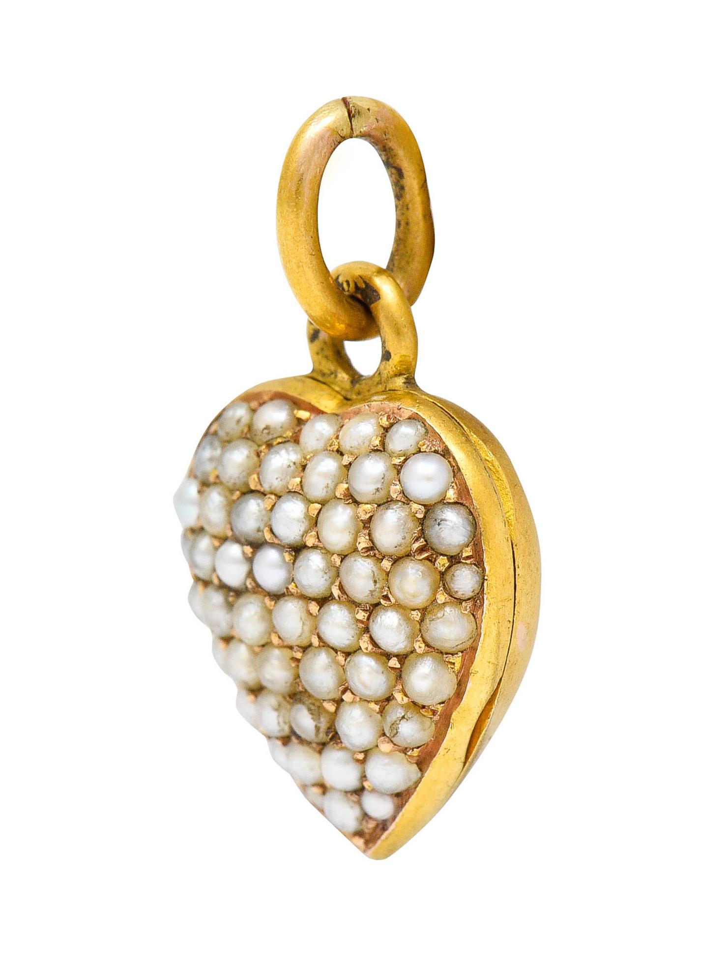 Heart shaped charm is set to front with natural freshwater pearls

1.5 mm in size with cream to white body color and good luster

Opens on a hinge to reveal to heart shaped recesses - both with removable glass covers

Maker's mark and tested as 18