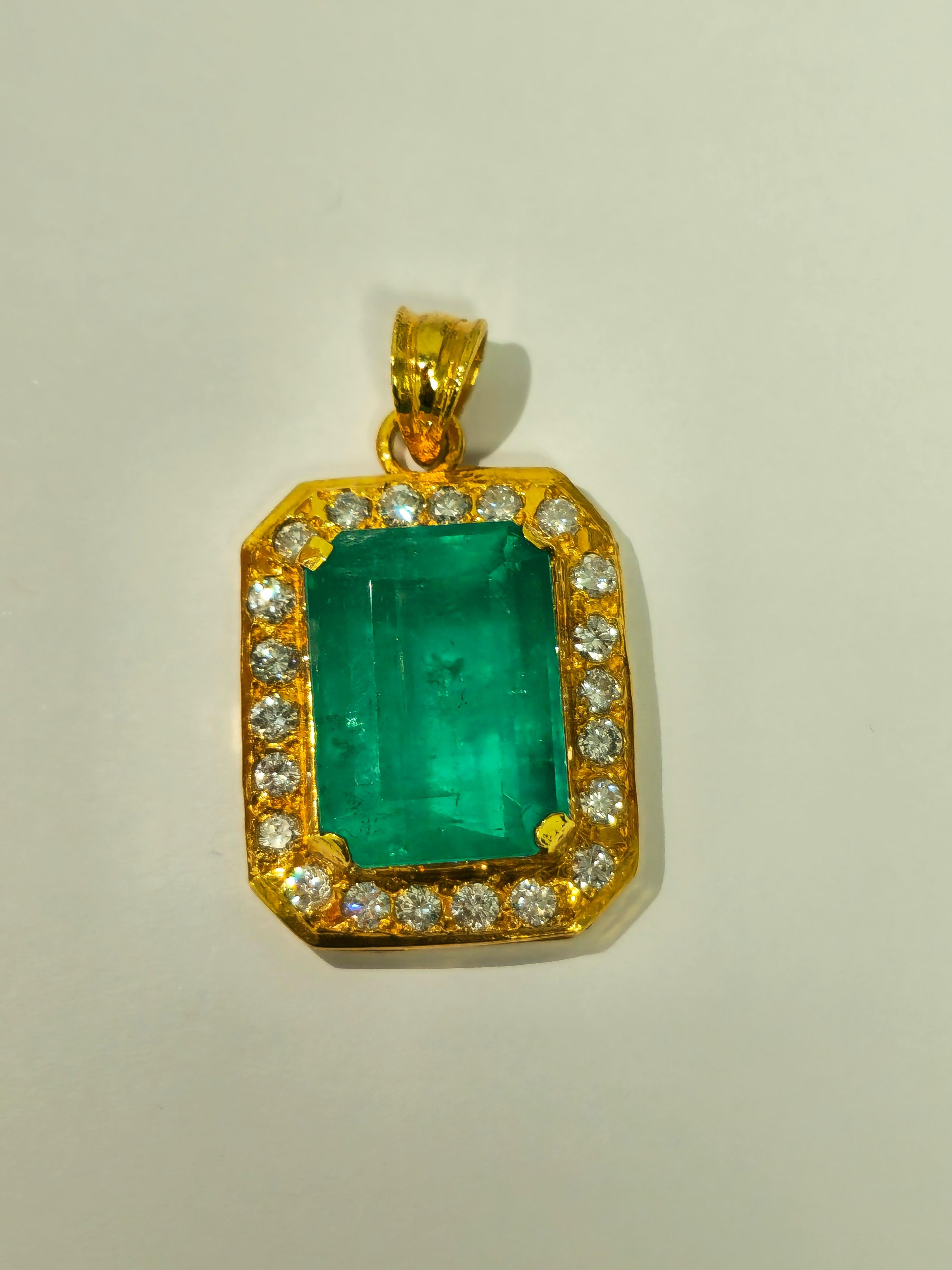 Cast in luxurious 21K yellow gold, this pendant is a showcase of opulence. Anchoring its allure is a breathtaking 17.00-carat Colombian emerald, sourced directly from the earth, and masterfully cut in an emerald shape. Accentuating its splendor are