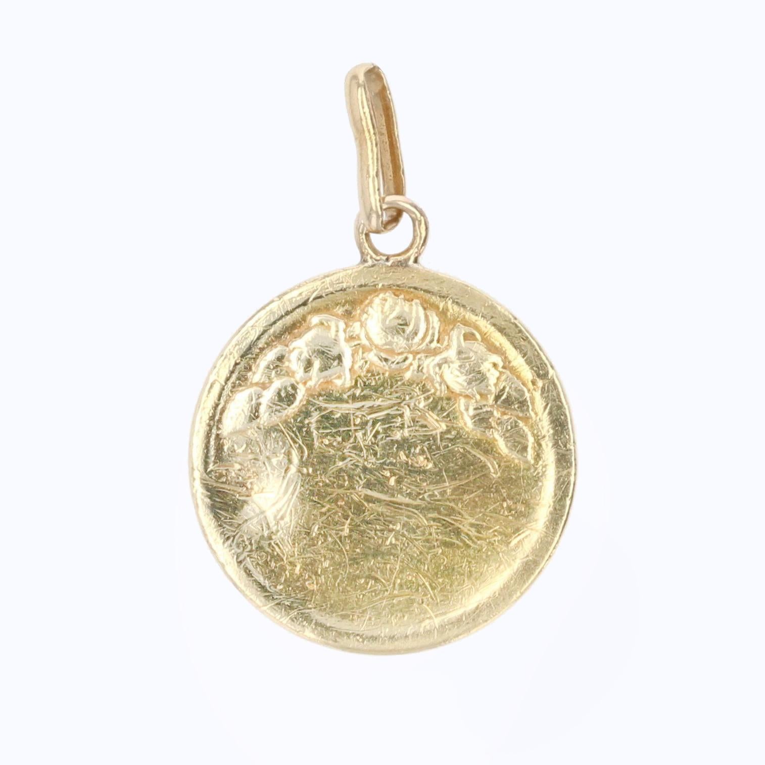 Medal in 18 karat yellow gold.
Antique medal of round shape, it represents the Virgin haloed. The back of this antique jewel is decorated with floral pattern.
Religious pendant signed E. Dropsy.
Height : 2,3 cm, width at the widest : 1,5 cm,