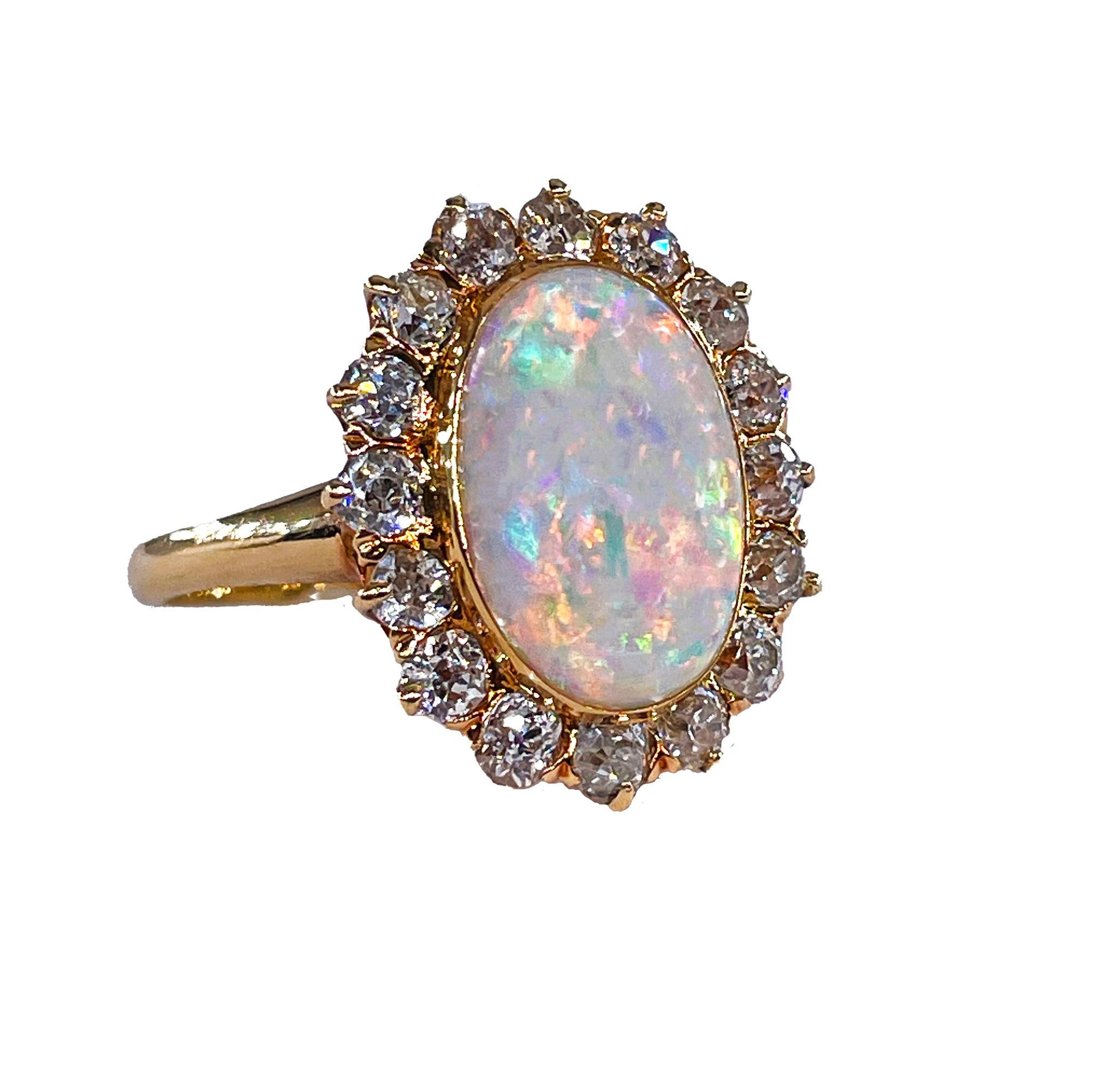 Un magnifico anello in oro 18k di fine secolo, tardo vittoriano, inizio edoardiano, con opale e diamanti a grappolo, circa 1900.
Questo opale australiano di cristallo mostra giochi di colore elettrici in una forma ovale. Il motivo a coriandoli con