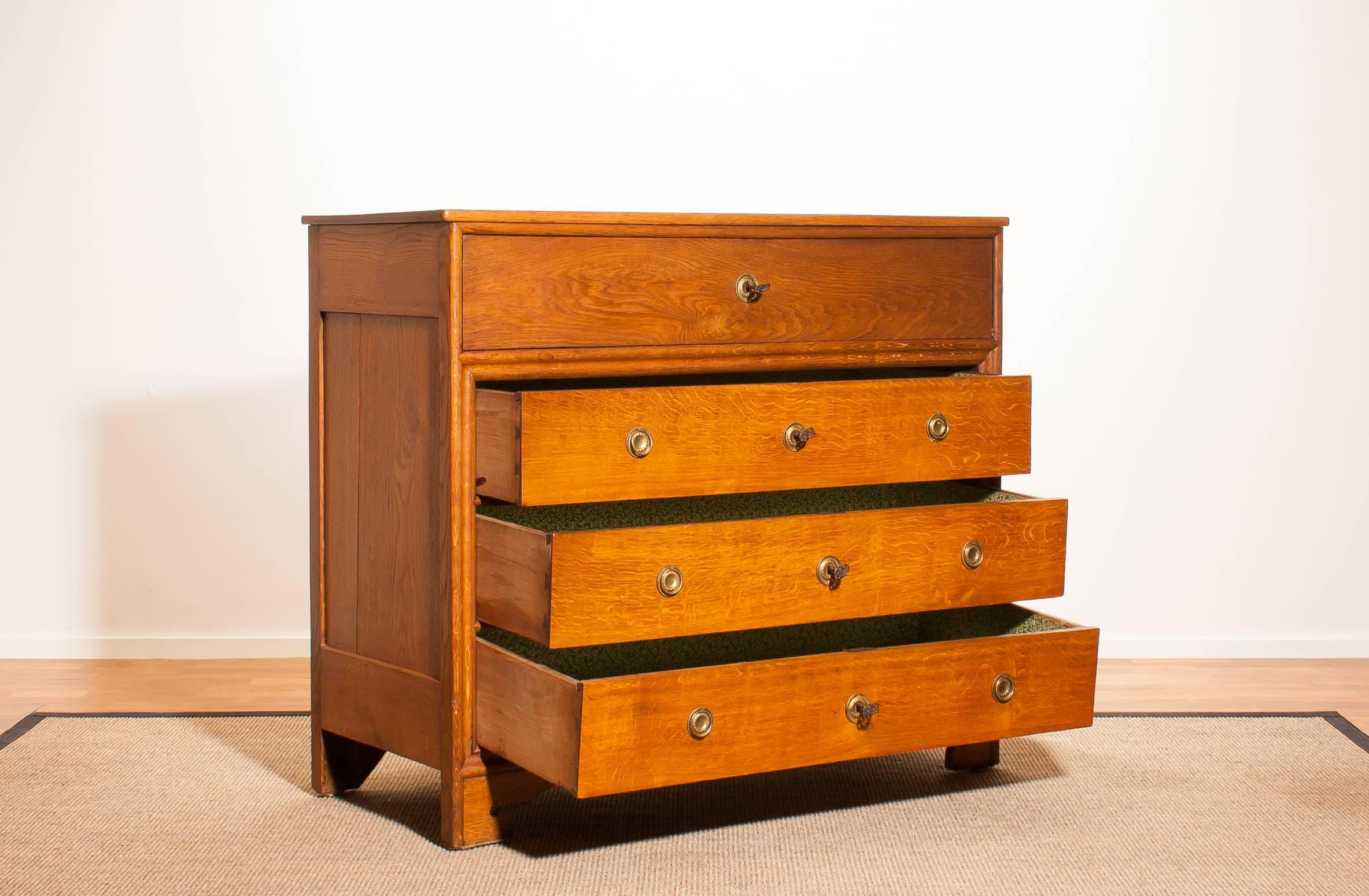 A beautiful oak commode, chest of drawers made in the Netherlands.
This cabinet features fittings made of brass and a secret drawer.
It has three big drawers.
There are four small drawers hide behind the upper drawer and an open space between