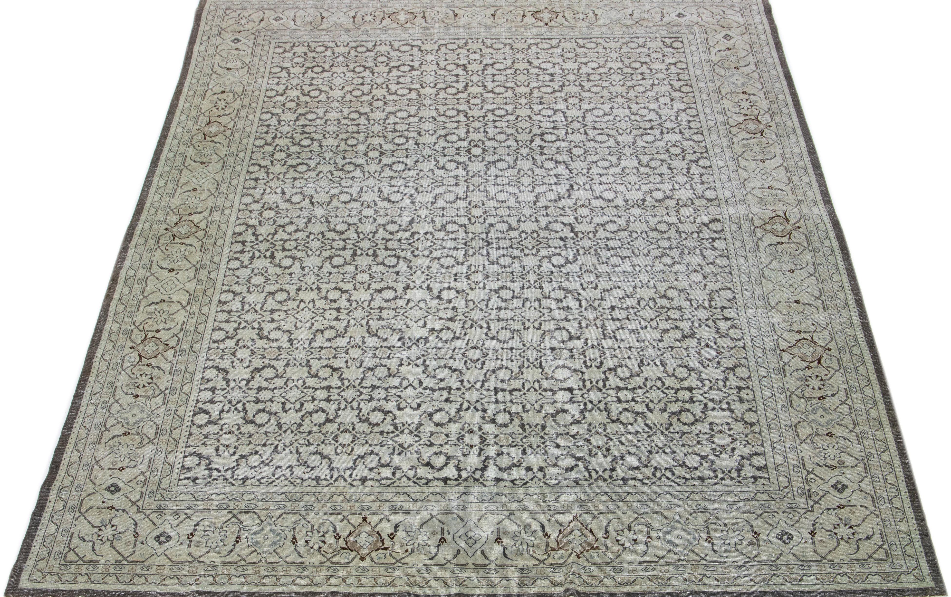 Questo antico tappeto Tabriz vanta un campo di colore grigio e presenta una squisita costruzione in lana annodata a mano, completata da accenni di beige e marrone in un motivo floreale all-over.

Questo tappeto misura: 10'6