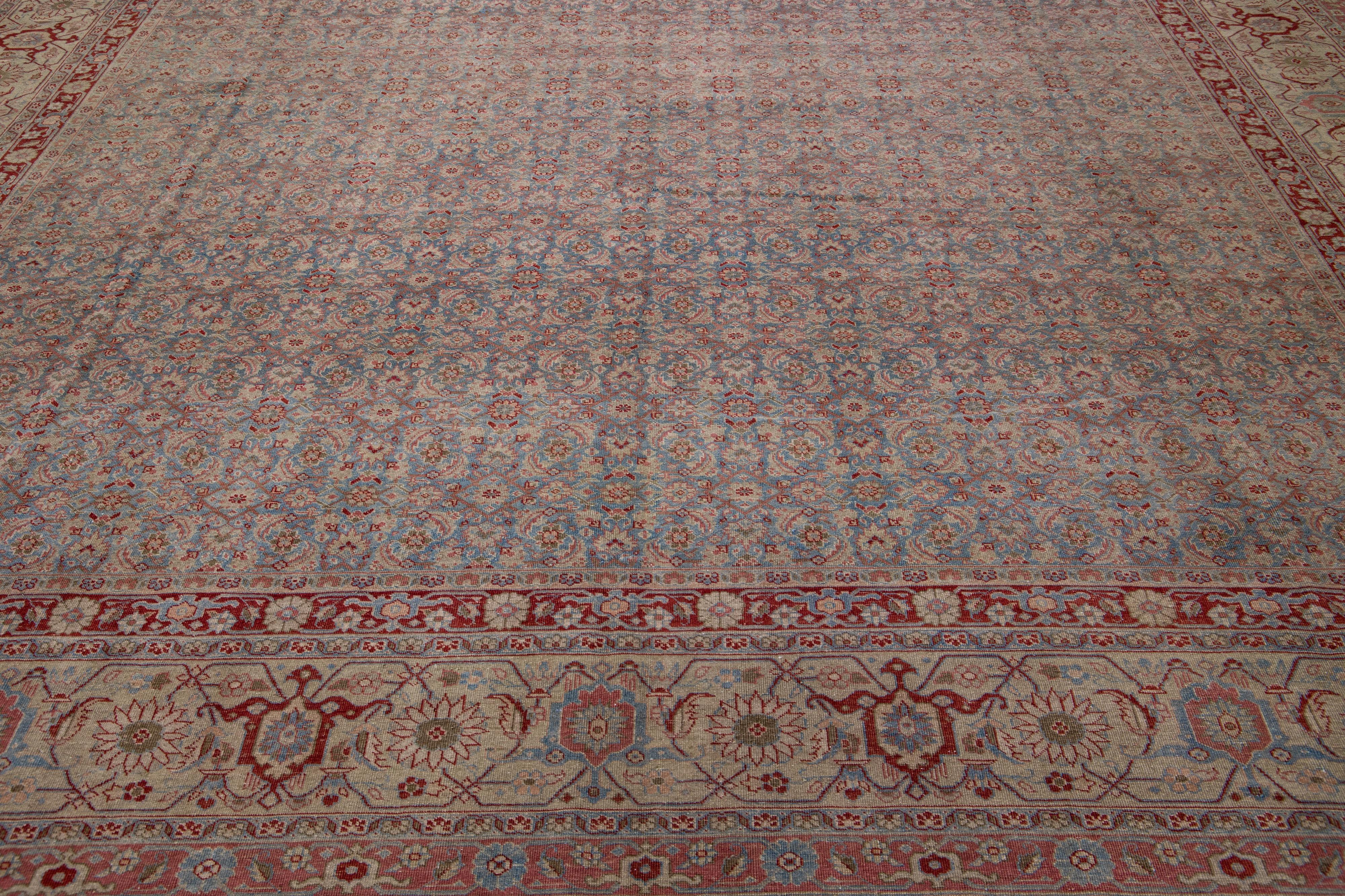 This antique Tabriz rug boasts a blue field and features exquisite, hand-knotted wool construction complemented by hints of red and beige in an all-over floral pattern. This unique craftsmanship is durable and timeless so it can be enjoyed for