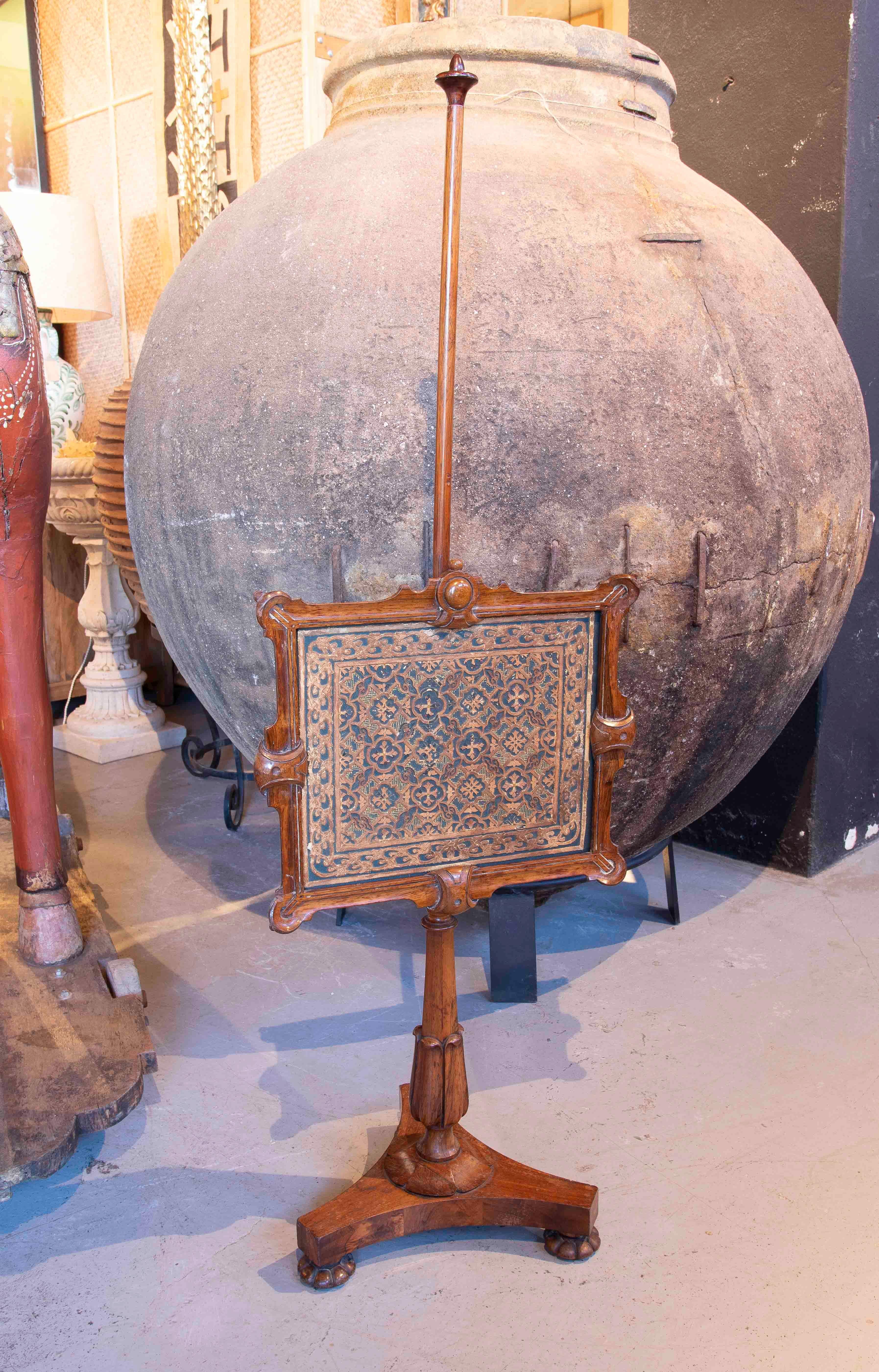 Preciosa pantalla de chimenea antigua de madera tallada, diseñada para proteger y decorar la zona de la chimenea. La pieza destaca por su exquisito panel central decorativo, con intrincados motivos geométricos y florales que le dan un aire refinado