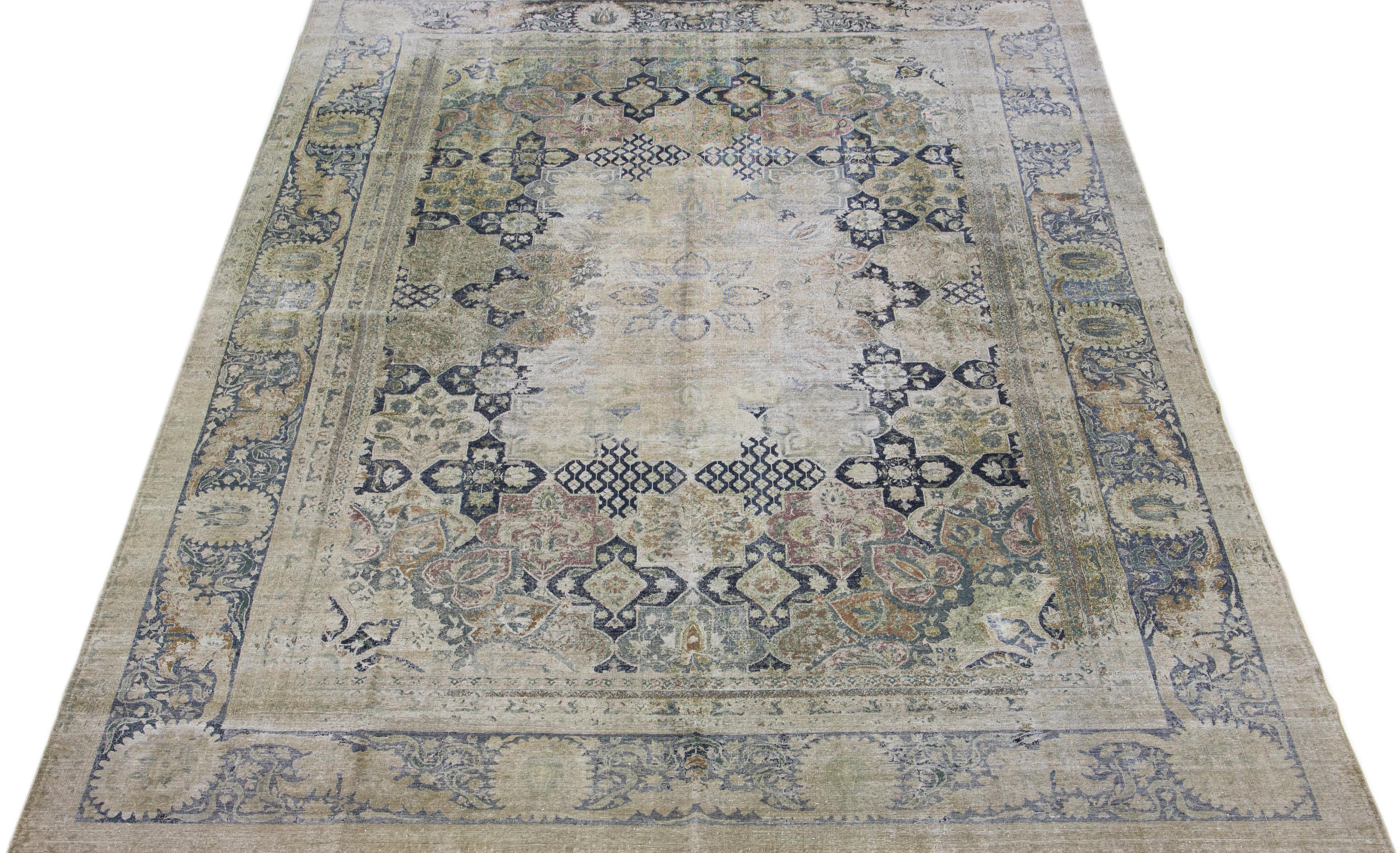 This antique Indian Larestan rug boasts a beige color field. It features exquisite, hand-knotted wool construction complemented by hints of blue, green, and brown in an all-over medallion floral pattern.

This rug measures: 10'9