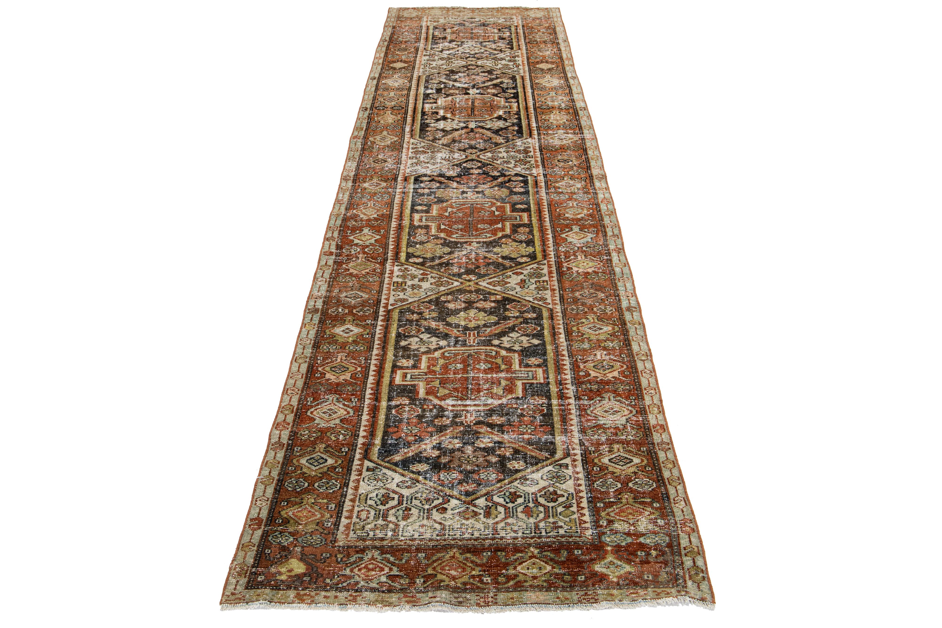 This Persian Malayer wool rug possesses an antique allure. It showcases hand-knotted wool in a brown color field. The tribal pattern is embellished with rust, blue, and goldenrod accents.

This rug measures 3'4