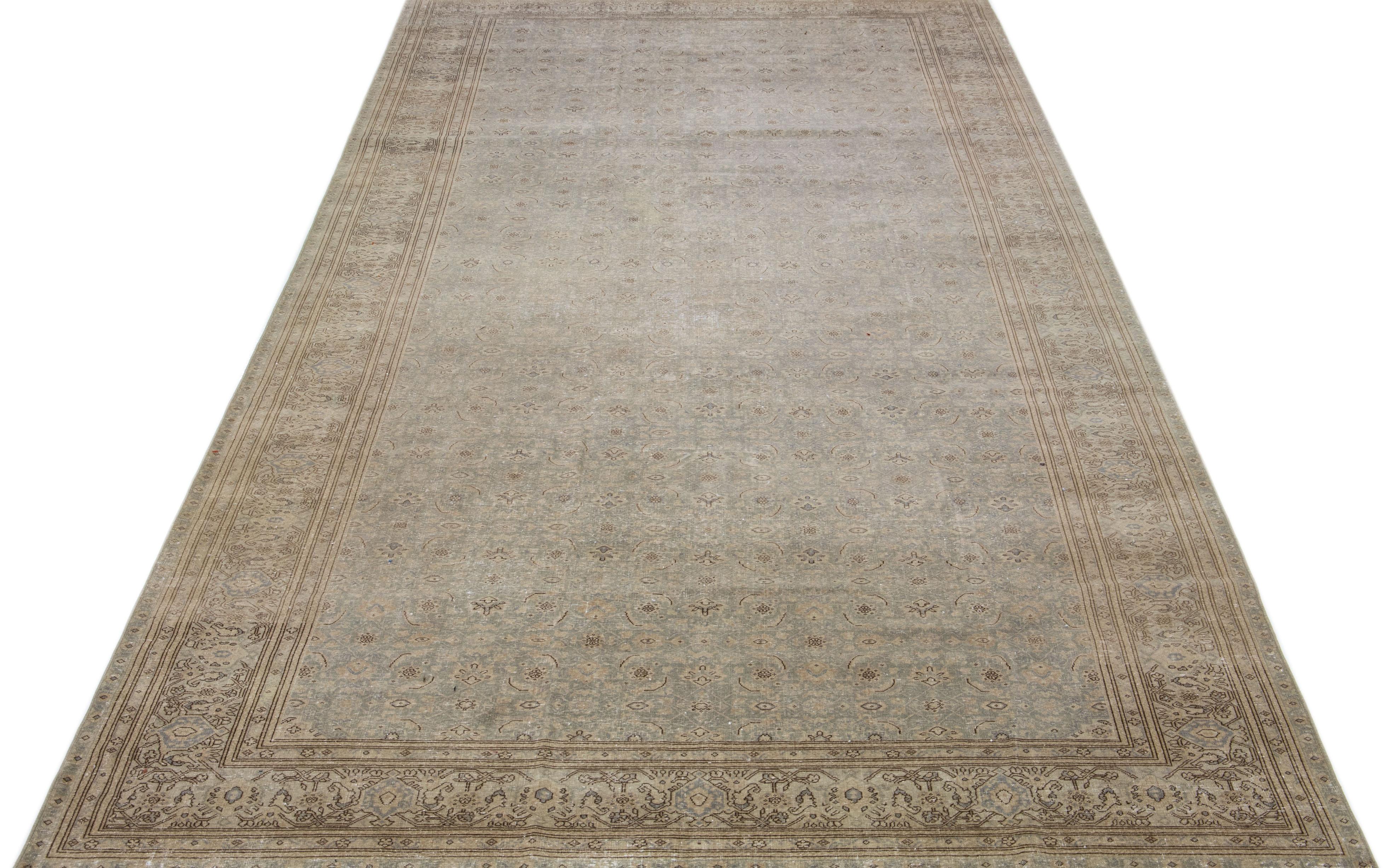 Beautiful hand-knotted antique Agra wool rug with a gray color field. This Persian rug has brown and blue accent colors in an all-over floral design. 

This rug measures: 7'2