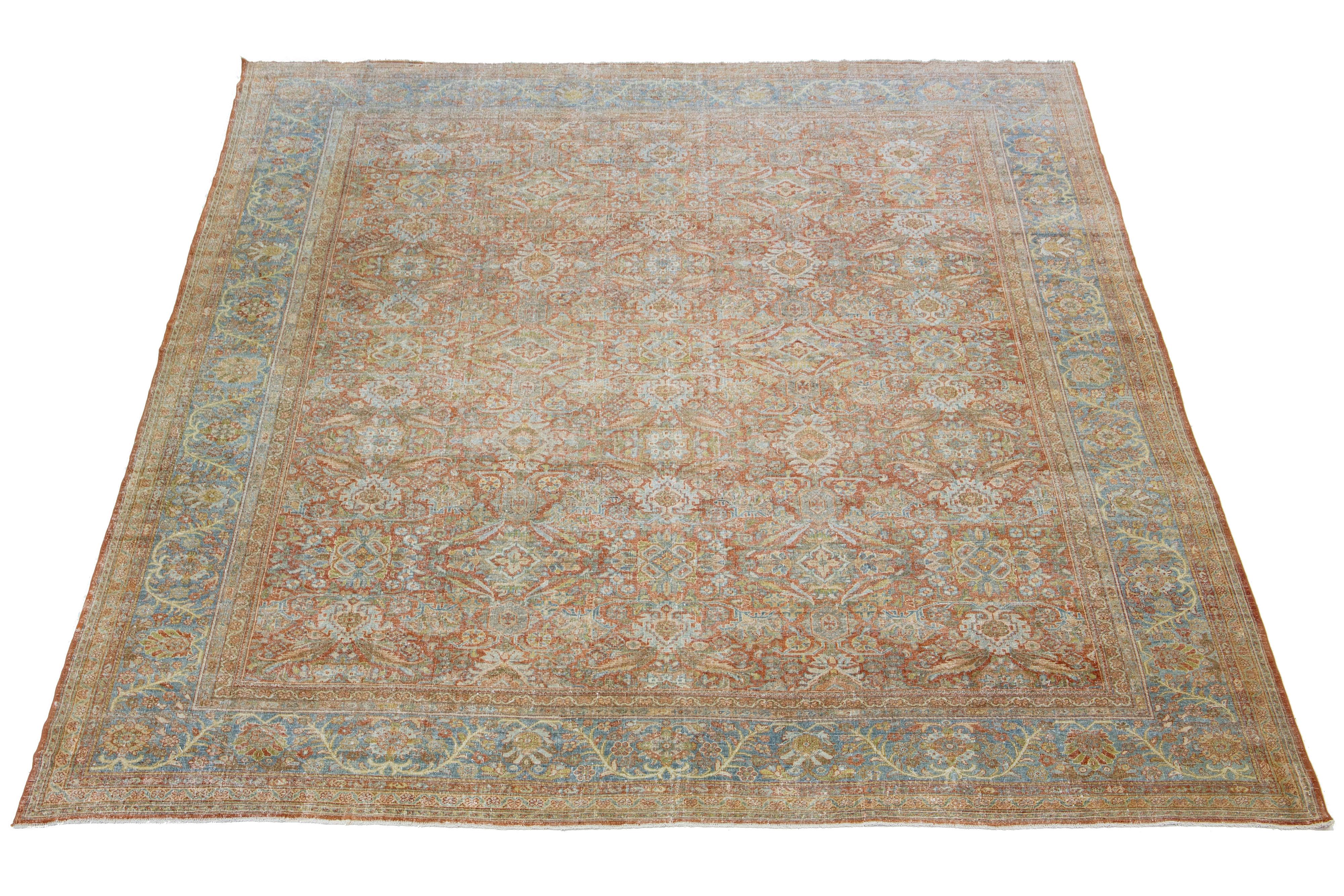 Beautiful Antique Mahal hand-knotted wool rug with a rust color field. This Persian rug has classic blue, green, beige, and brown hues throughout the floral motif.

This rug measures 11'10' X 14'.
     