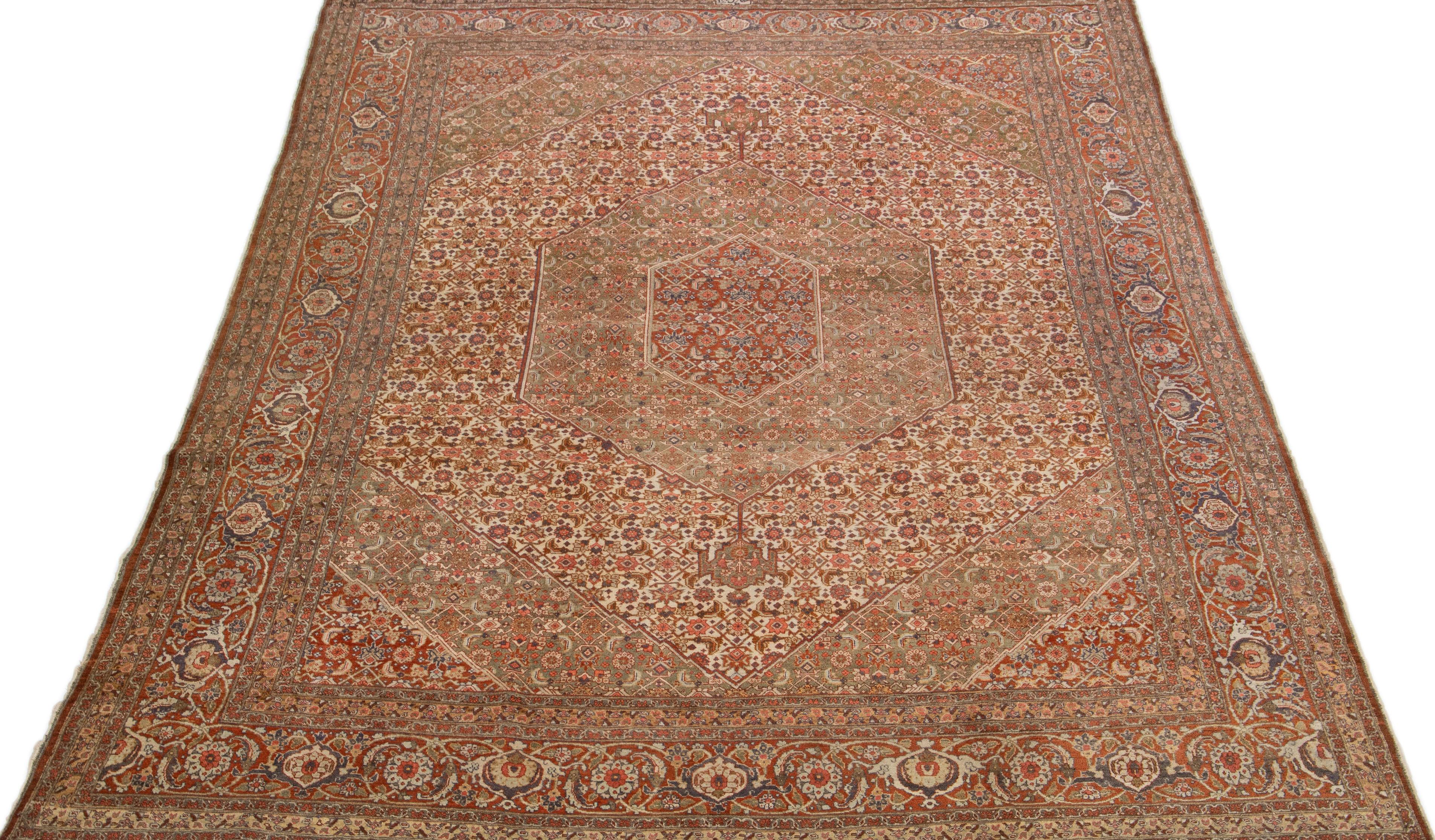 Beautiful antique Persian distressed hand-knotted wool rug with a beige and green color field. This piece has a rusted frame with peach, blue, and brown accents in a gorgeous all-over medallion floral design.

This rug measures: 9'4' x